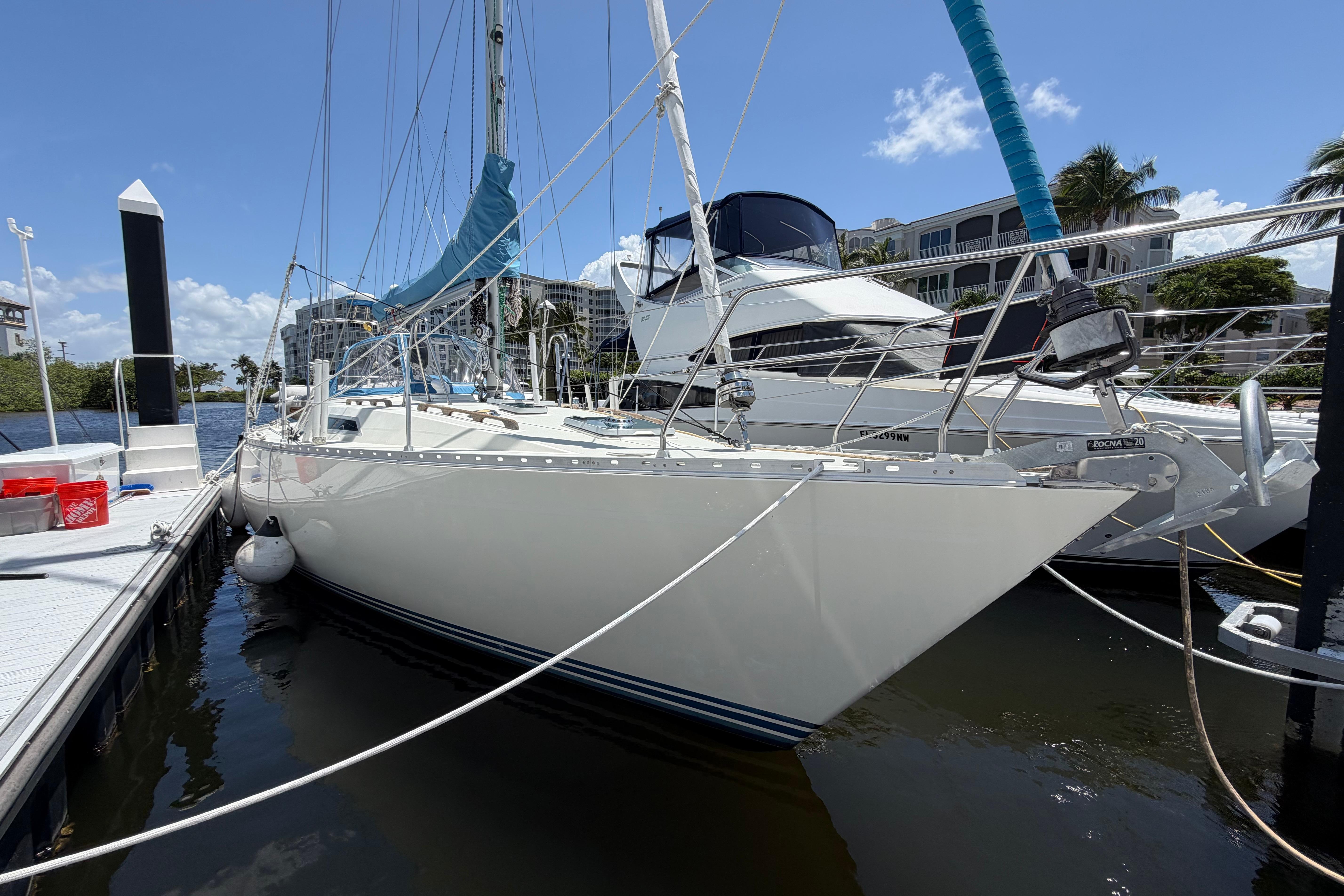 1987 Moody 376 sailboat docked at marina under clear blue sky.