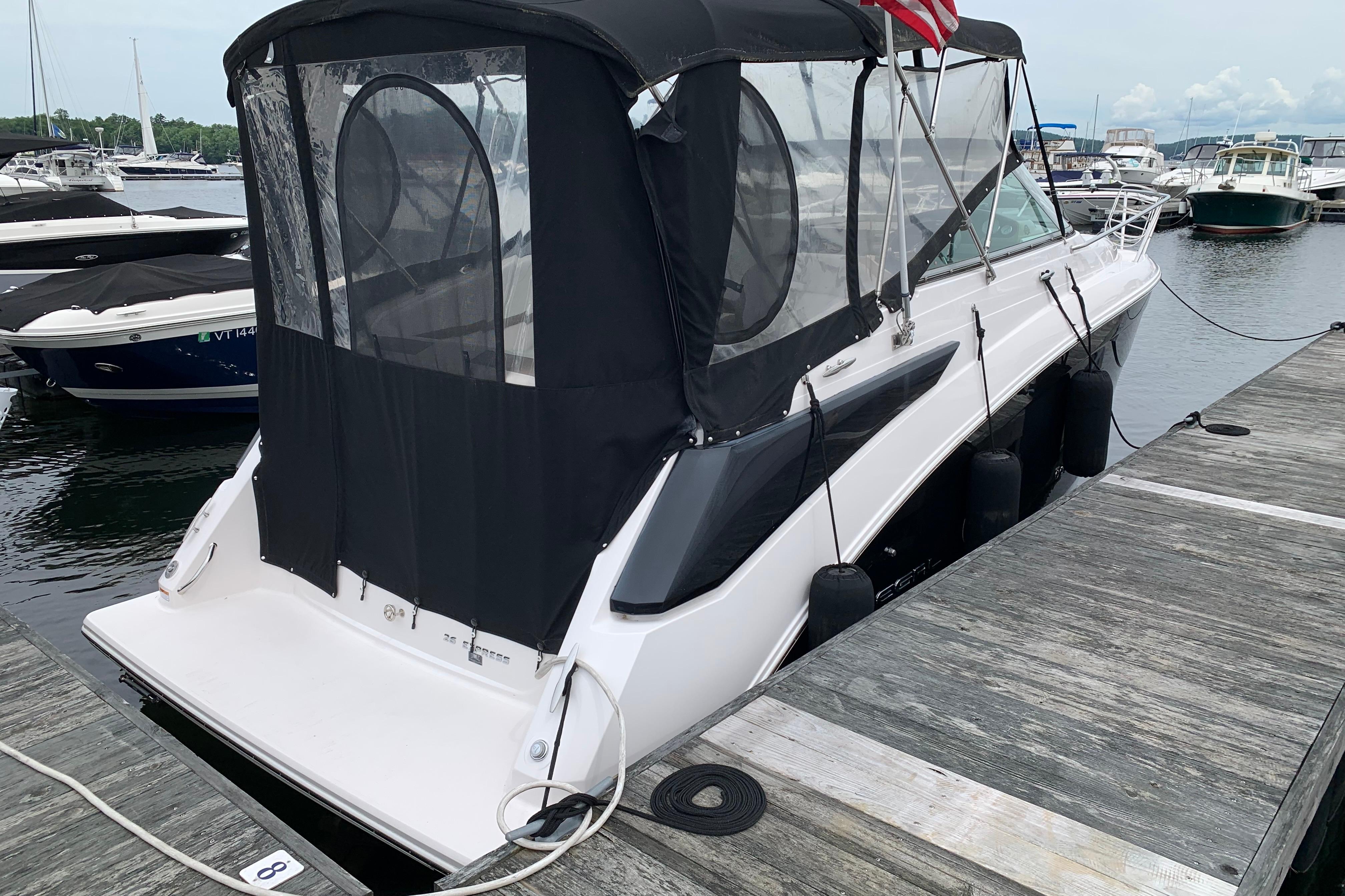 2017 Regal 26 Express boat docked with black canopy and American flag.