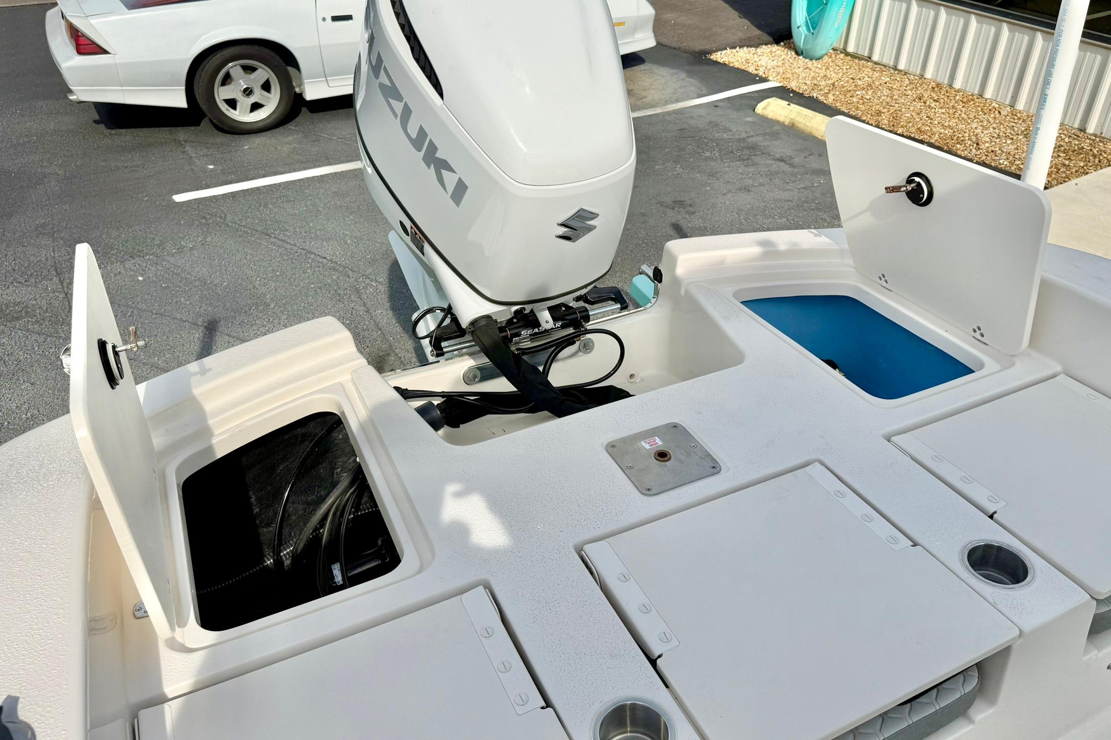 2026 Carolina Skiff 24 Ultra Elite boat with Suzuki outboard motor and storage compartments.
