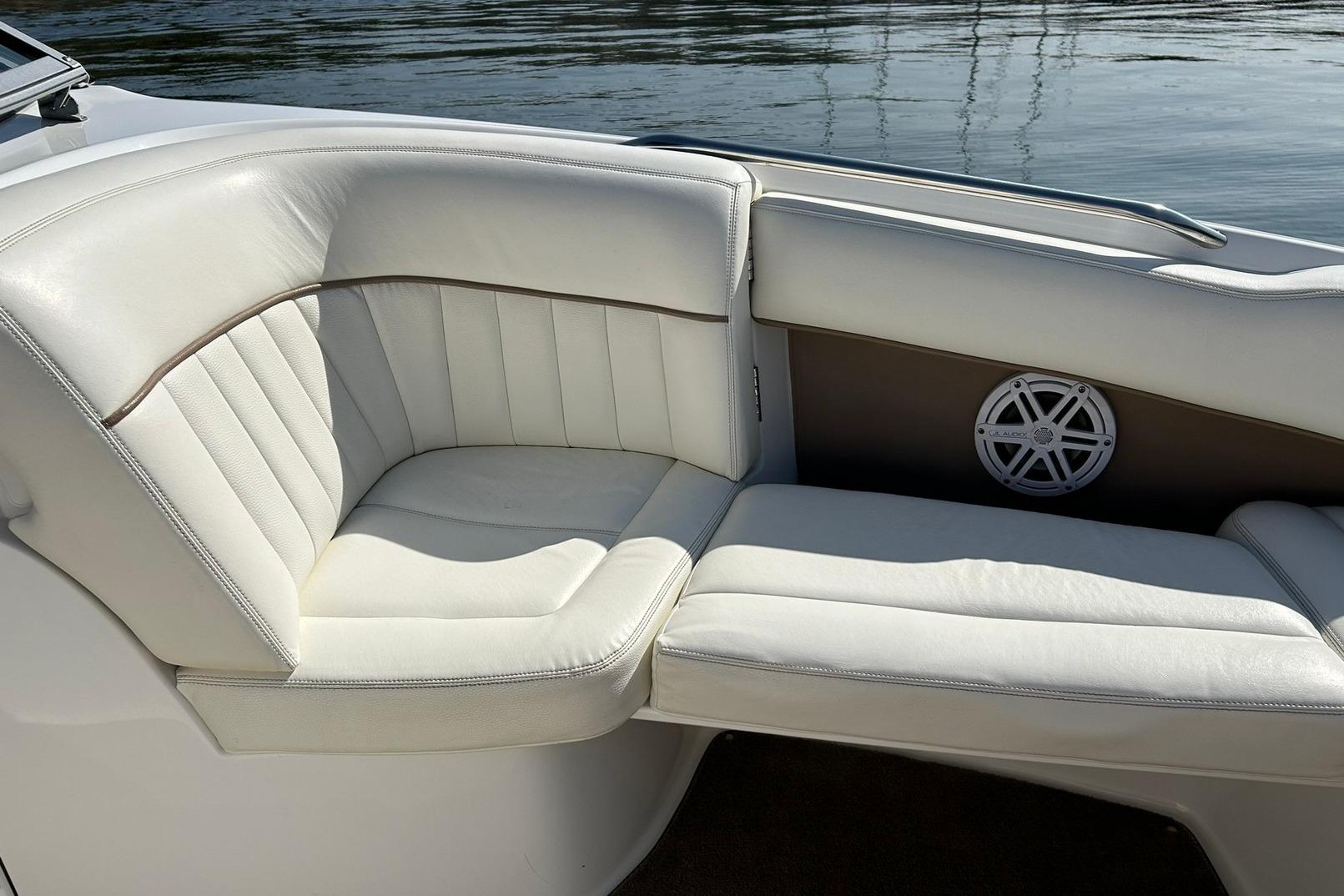 Luxurious white seating on a 2007 Cobalt 232 boat, with water in the background.