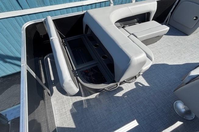 2026 Sun Tracker Party Barge 18 DLX interior with gray seating and storage compartments.