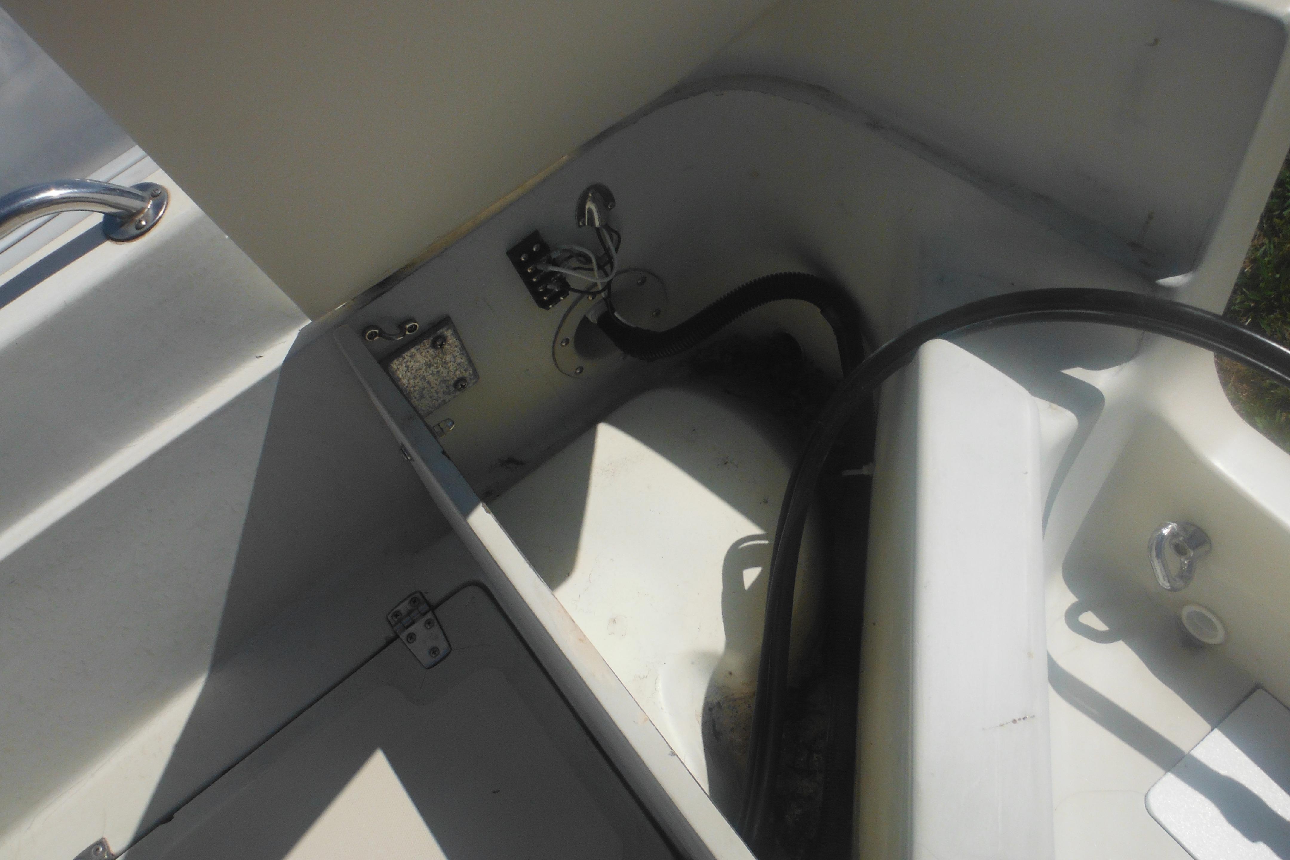 Interior view of a 1991 Boston Whaler 16 SL boat, showing storage compartment details.