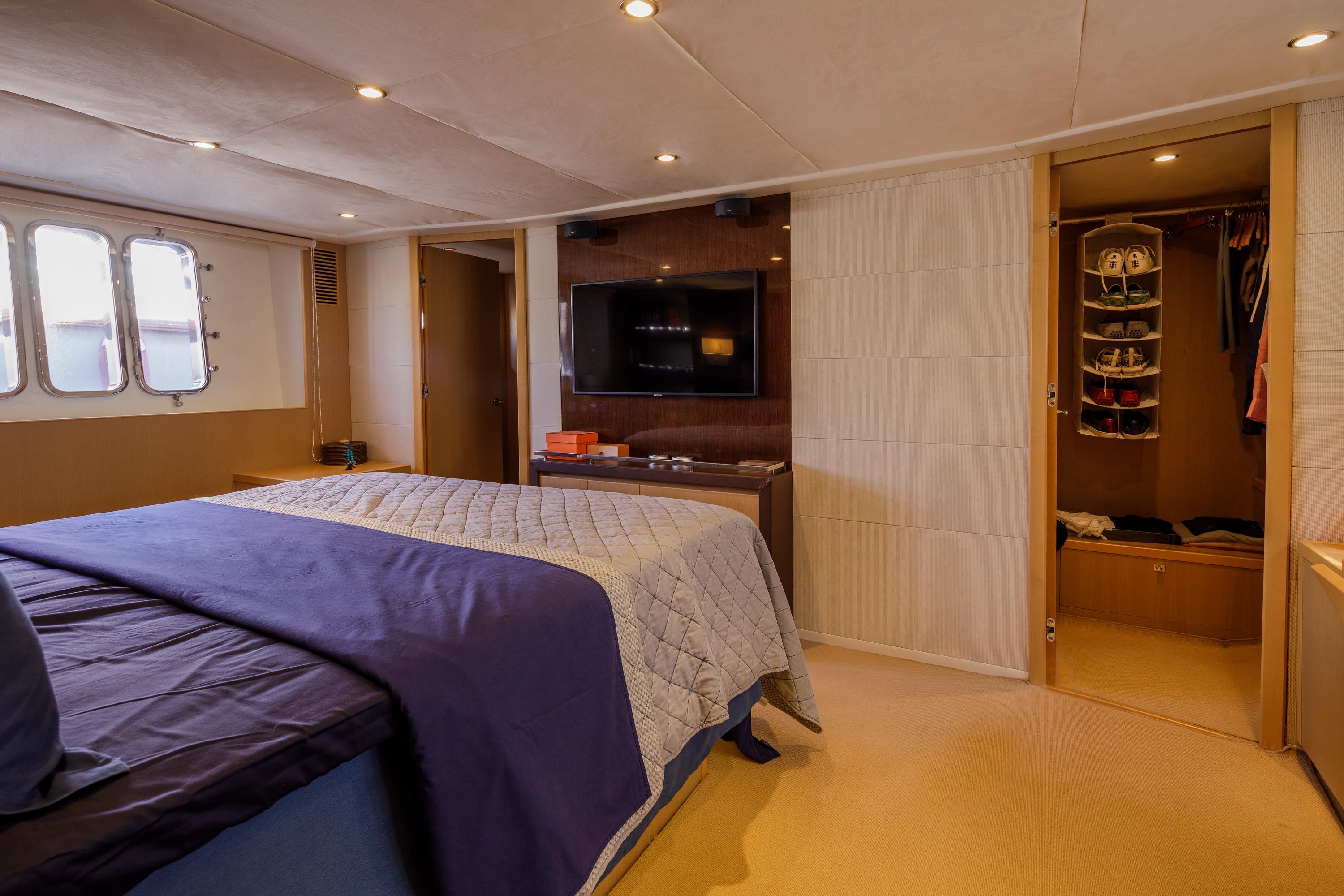 Luxurious bedroom on 2010 Princess V78 yacht with cozy bedding and modern amenities.