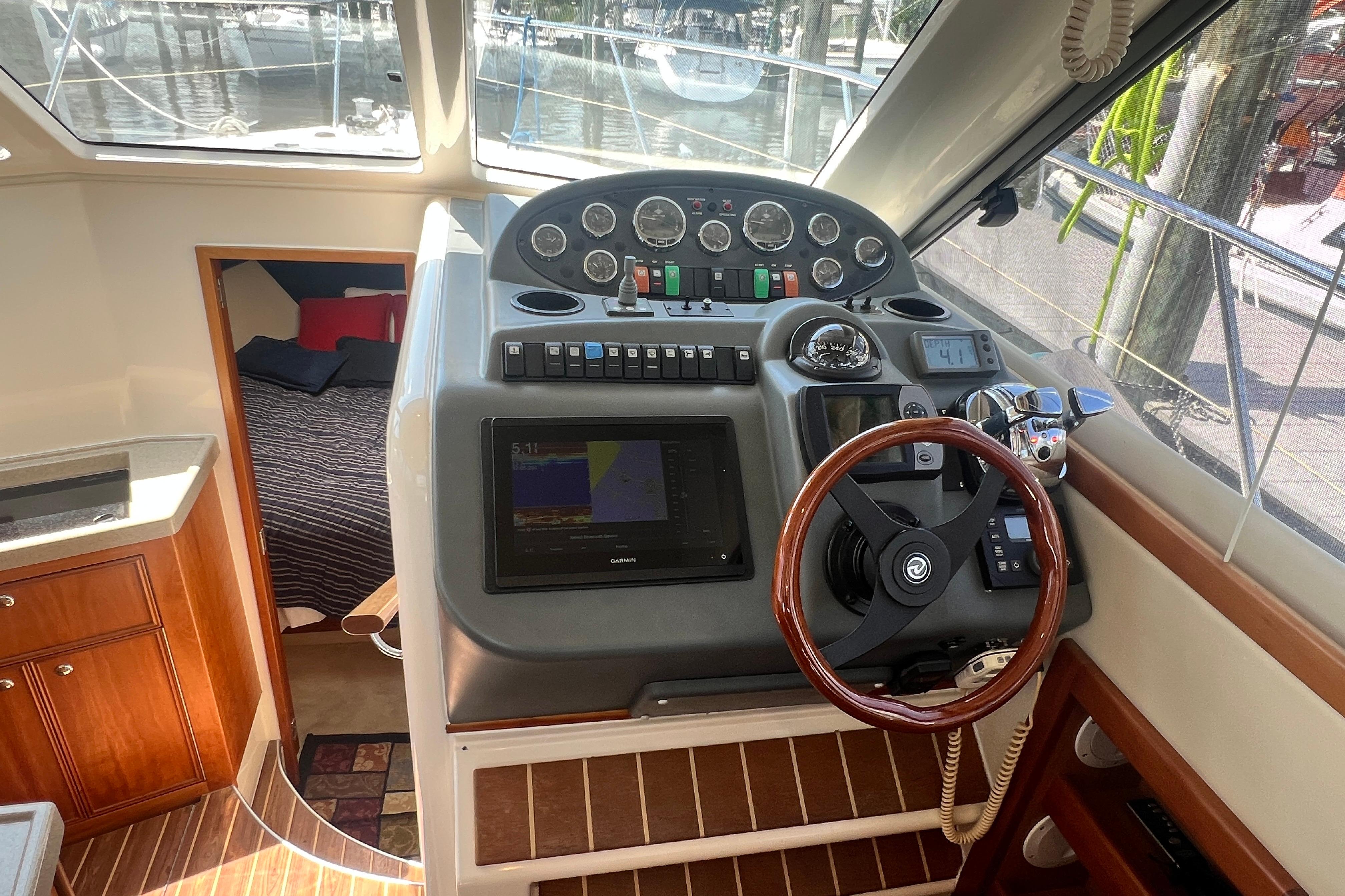 2007 Riviera 33 Flybridge helm with navigation controls and cozy cabin view.