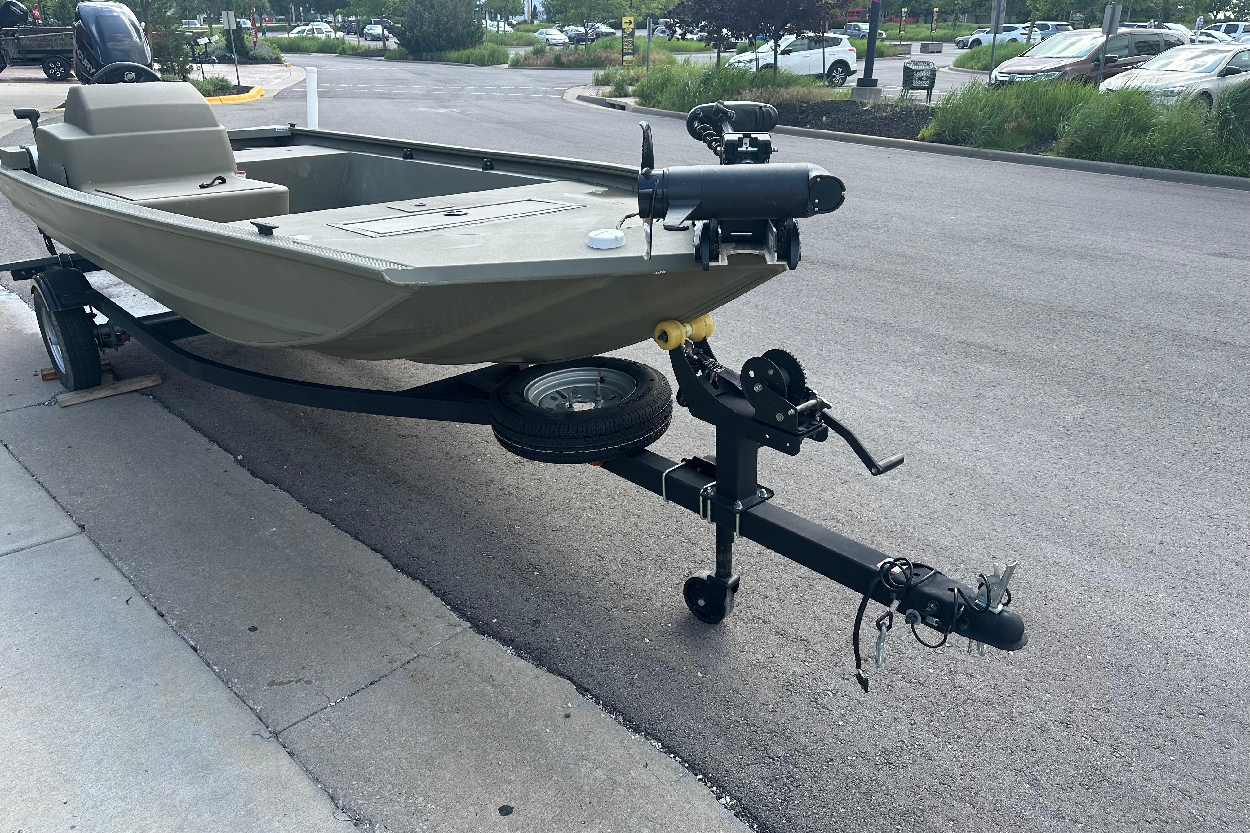2024 Tracker Grizzly 1648 SC boat on trailer, parked on pavement.