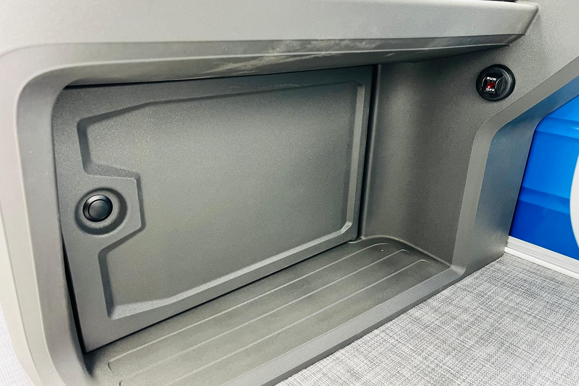 2026 Sun Tracker Party Barge 22 RF DLX storage compartment with sleek design and button feature.