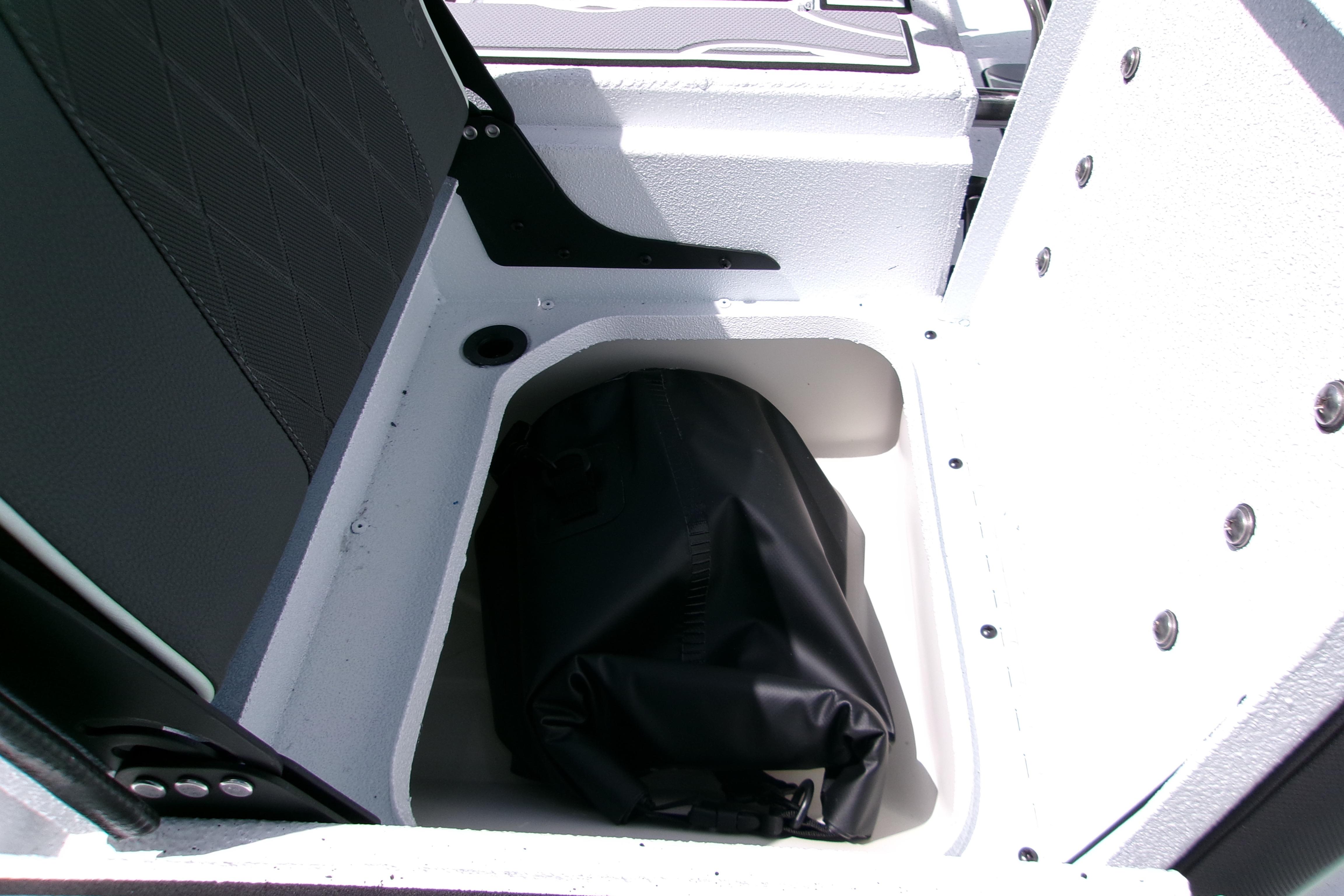 Storage compartment in 2027 Xpress H22B Bay boat with black bag inside.