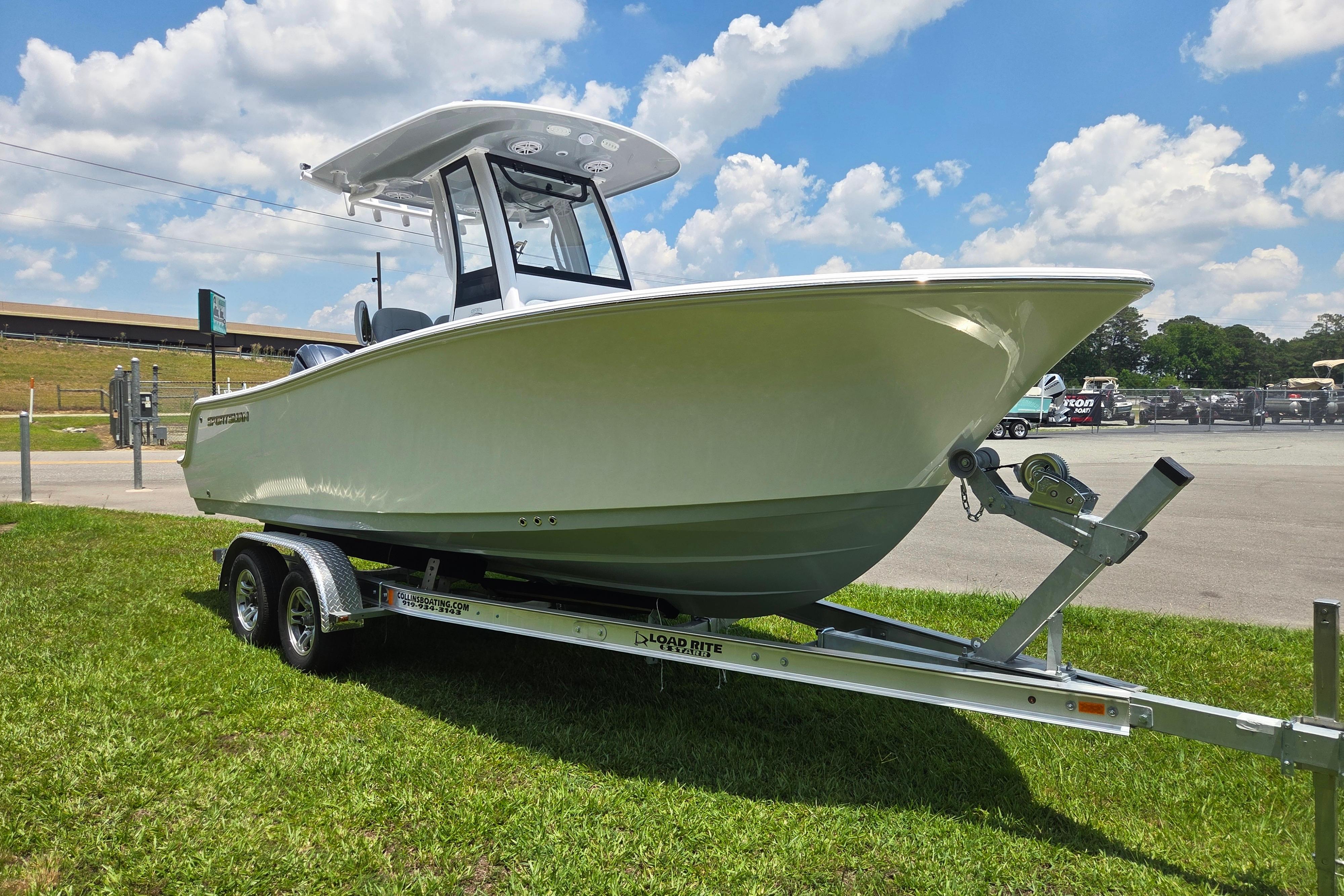 2026 Sportsman Open 212 Center Console boat on trailer, parked on grass under blue sky.