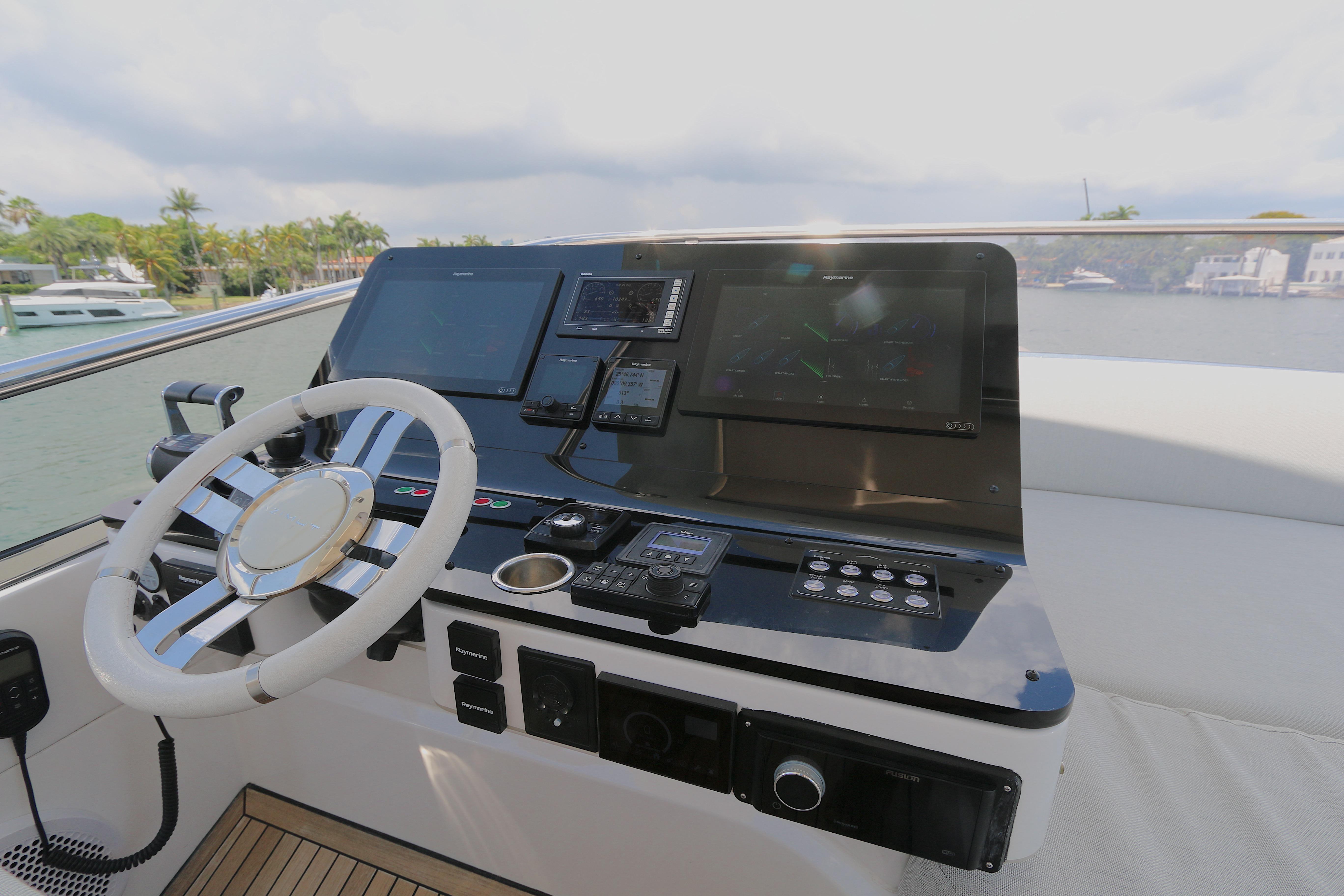 Cockpit of 2020 Azimut 55 yacht with modern navigation controls and steering wheel.