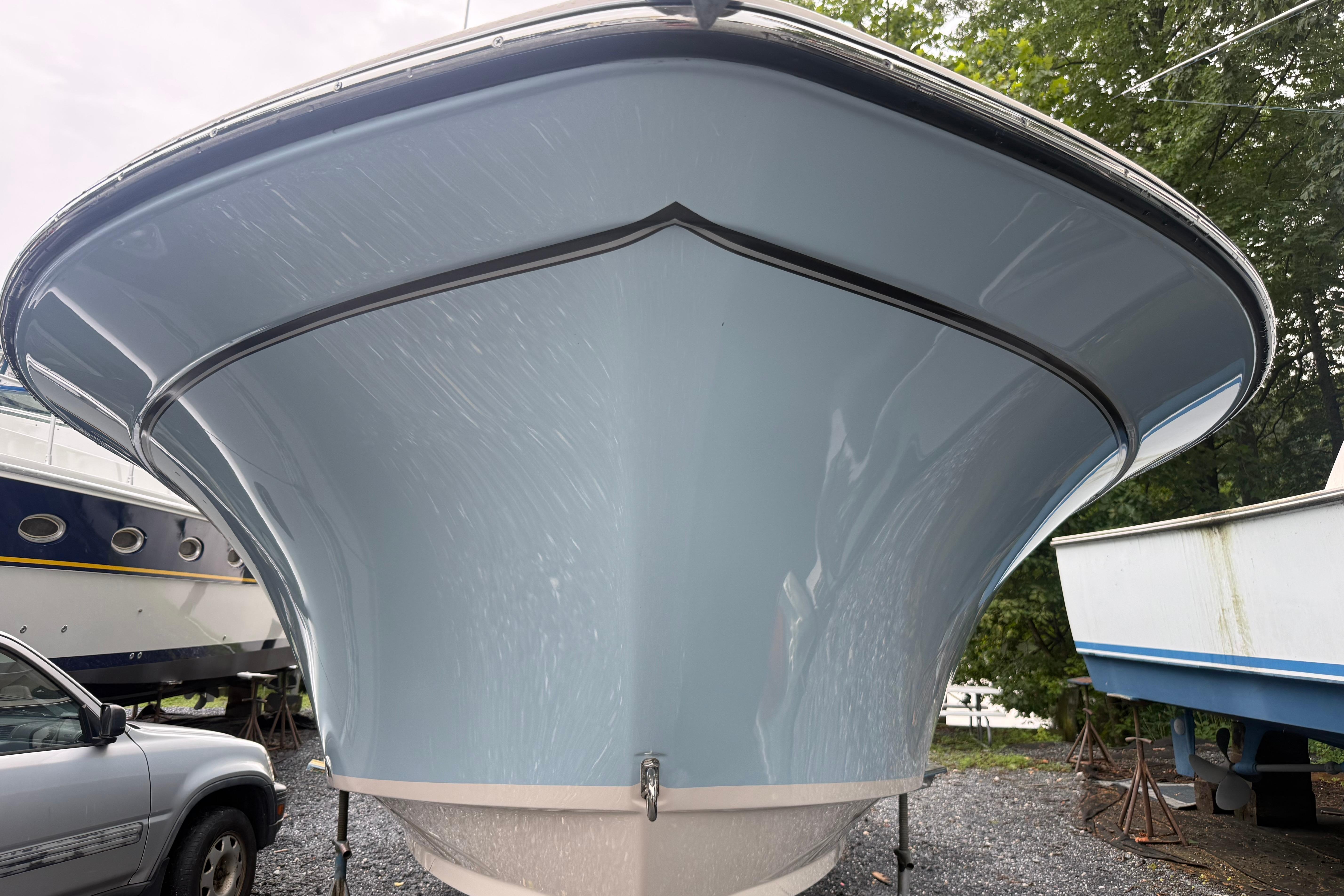 2022 Grady-White Freedom 235 boat, front view, parked outdoors near other boats.