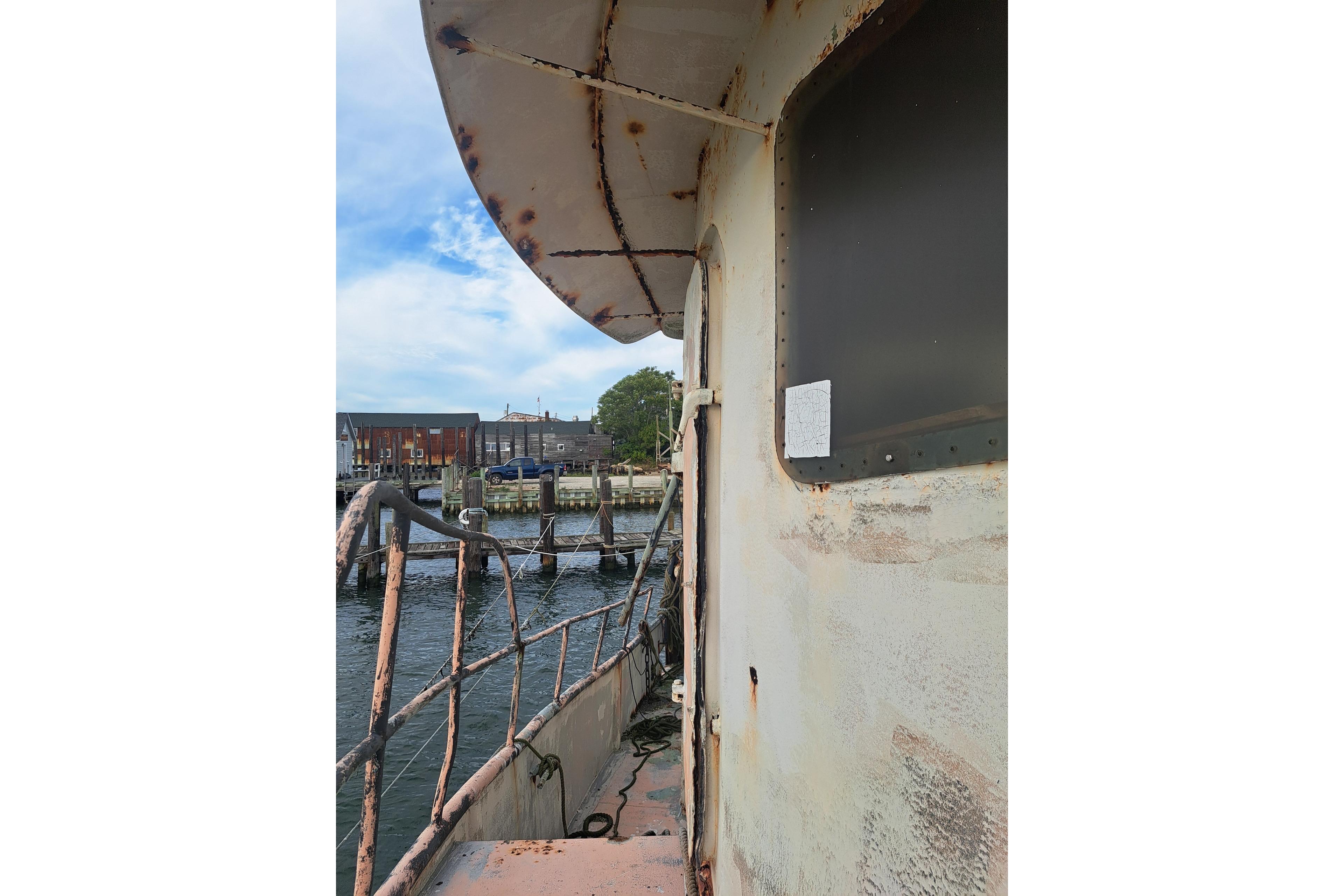 Rustic 1979 Custom Steel Trawler Dragger docked by the waterfront.