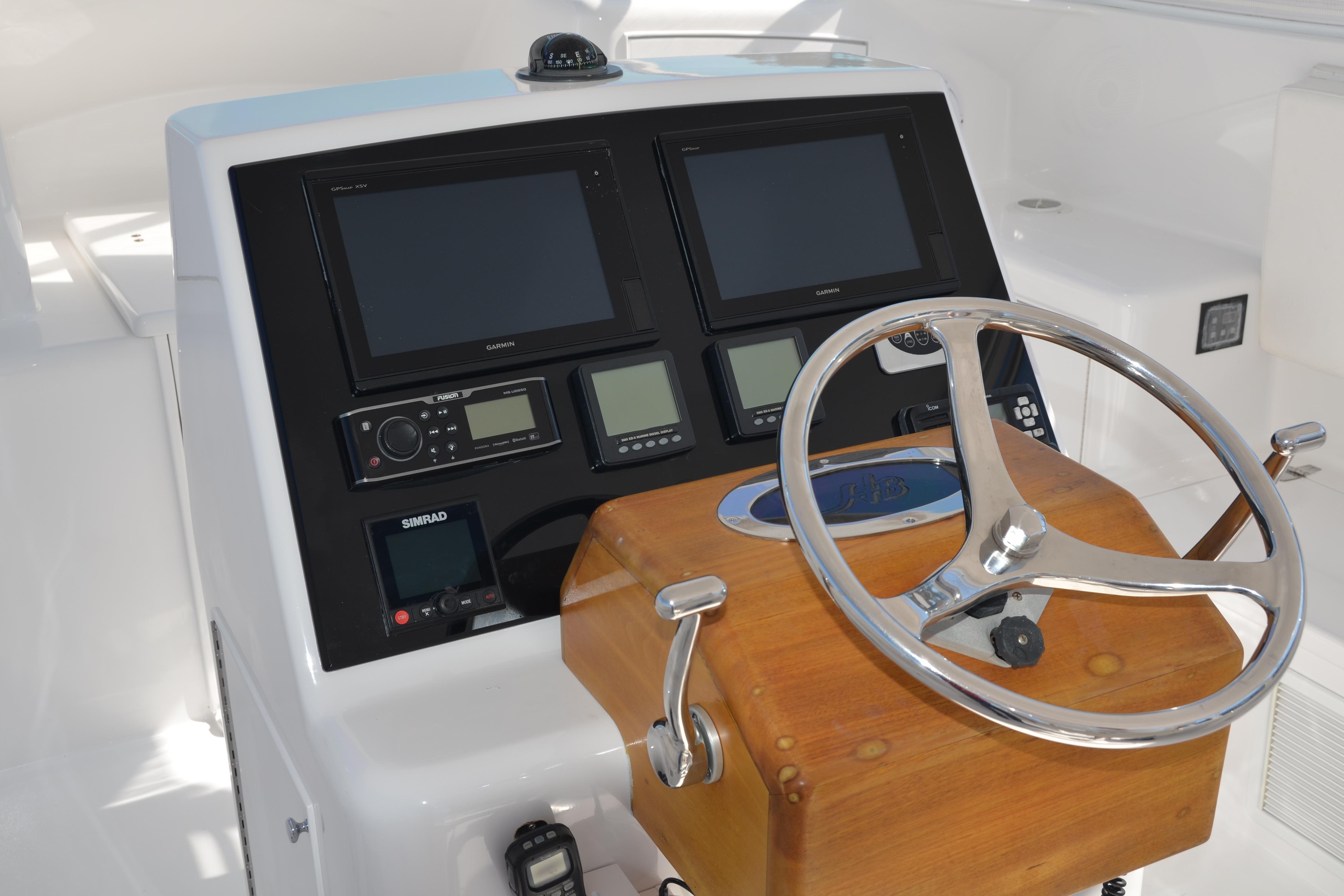 Helm of 2006 Custom Carolina Heritage Express boat with navigation screens and wooden steering wheel.