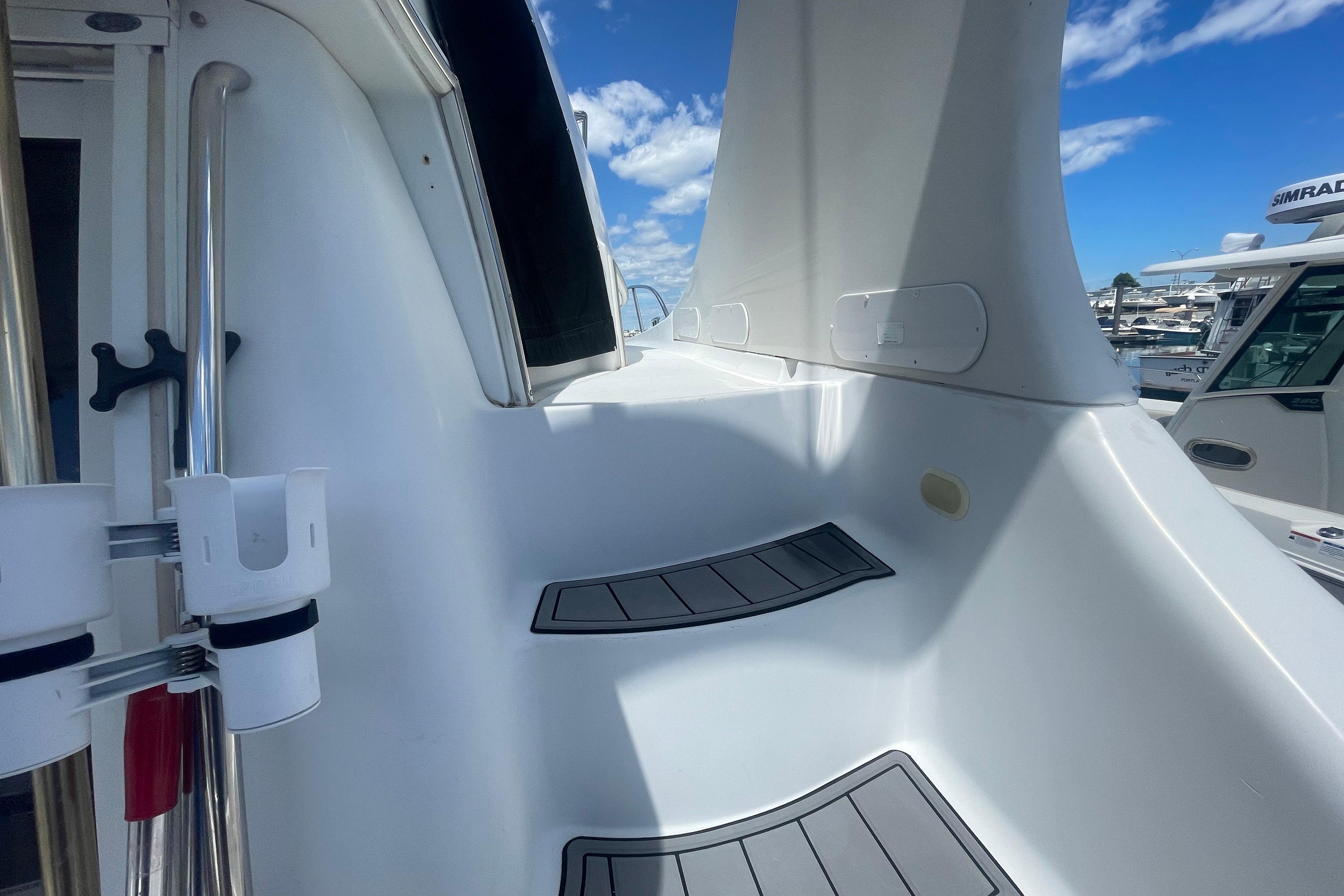 2002 Carver 410 Sport Sedan yacht deck with steps and railing under blue sky.