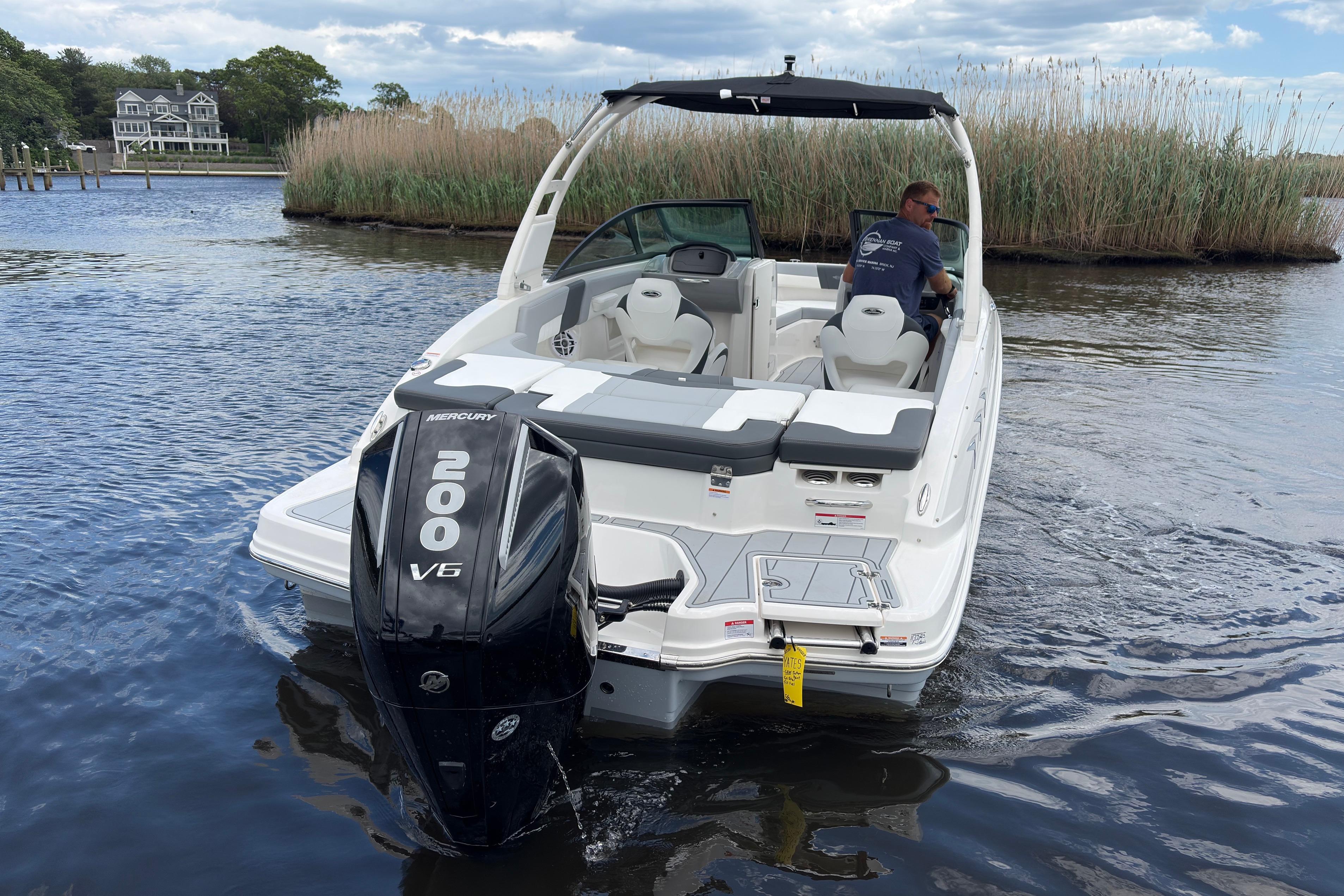 2026 Chaparral 23 SSi OB boat with Mercury 200 V6 engine on a serene lake.