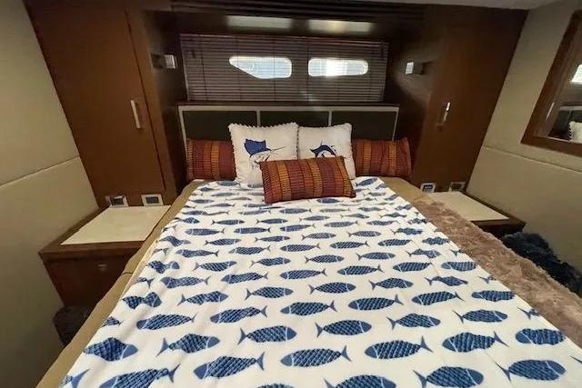 Luxurious 2016 Sea Ray Sundancer 510 cabin with fish-patterned bedding and elegant decor.