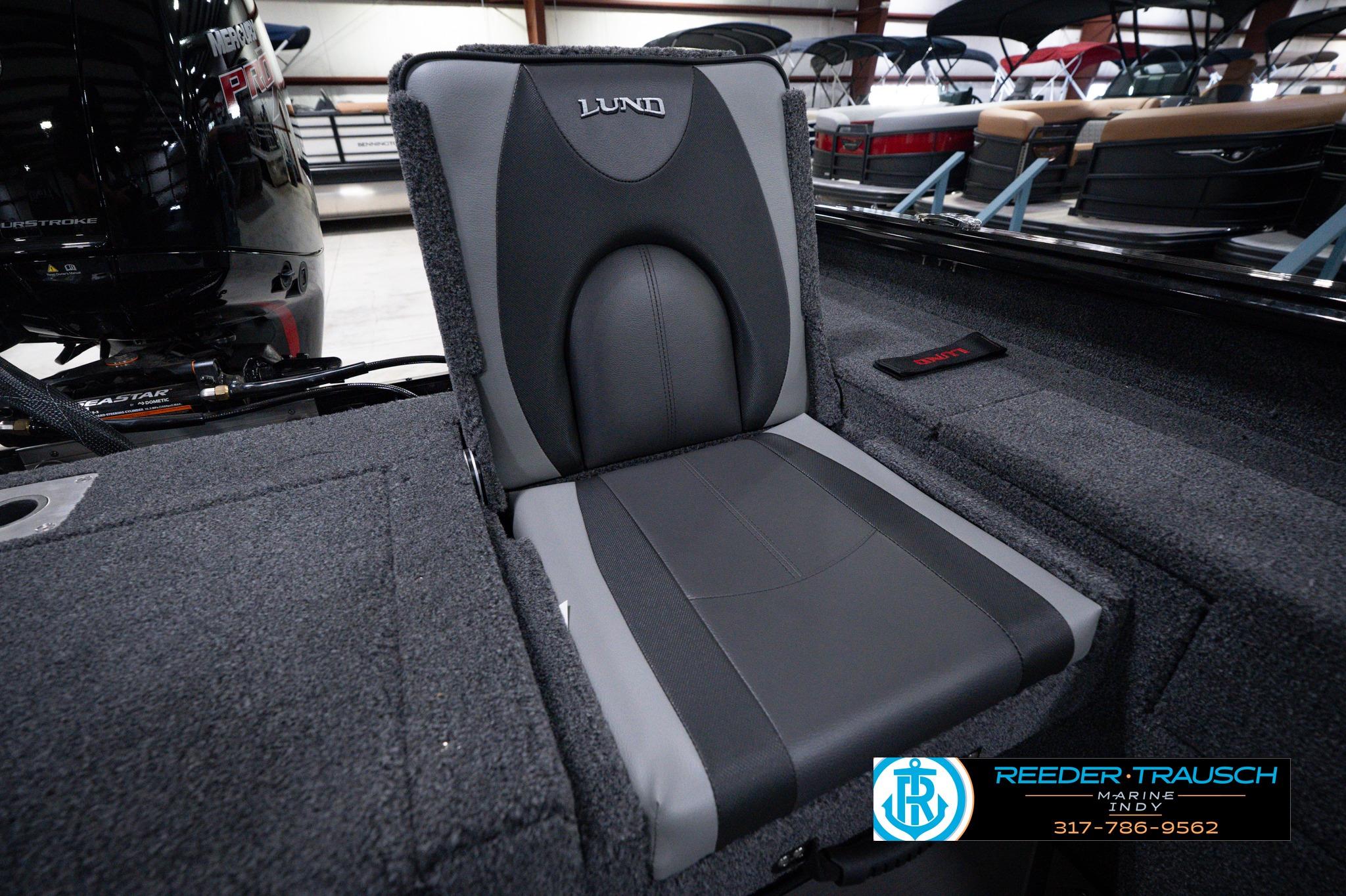 2026 Lund 1875 Impact XS SS boat seat with sleek black and gray design in showroom.