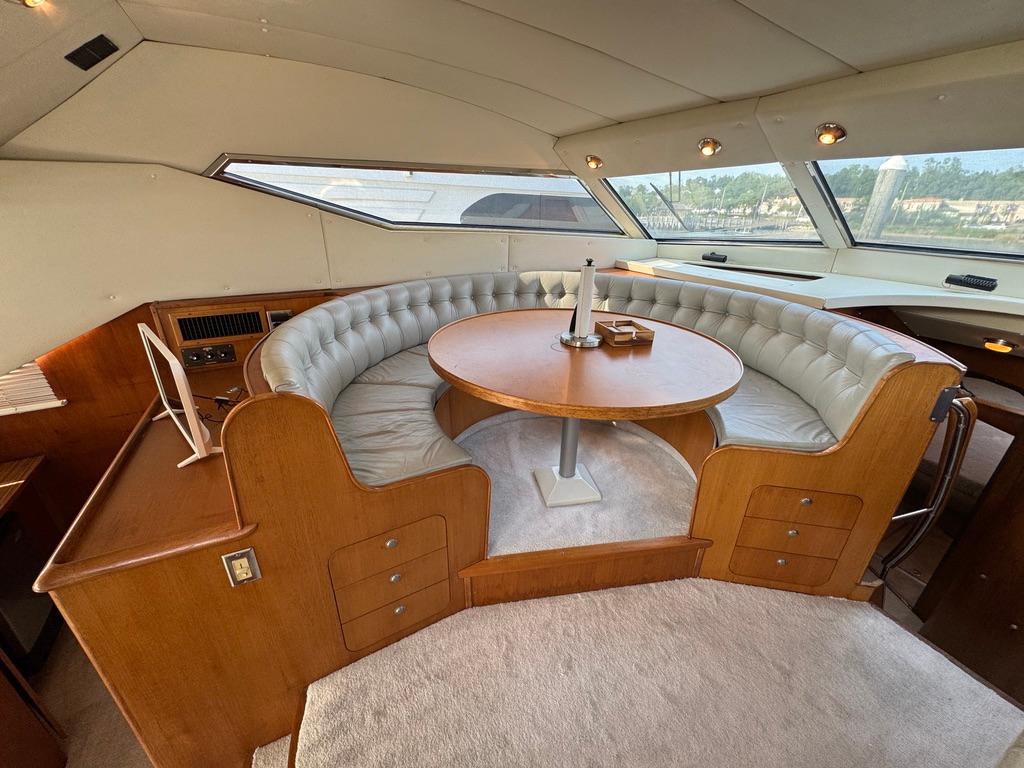 Luxurious 1989 Birchwood 62 Cockpit Motor Yacht interior with elegant circular seating and table.