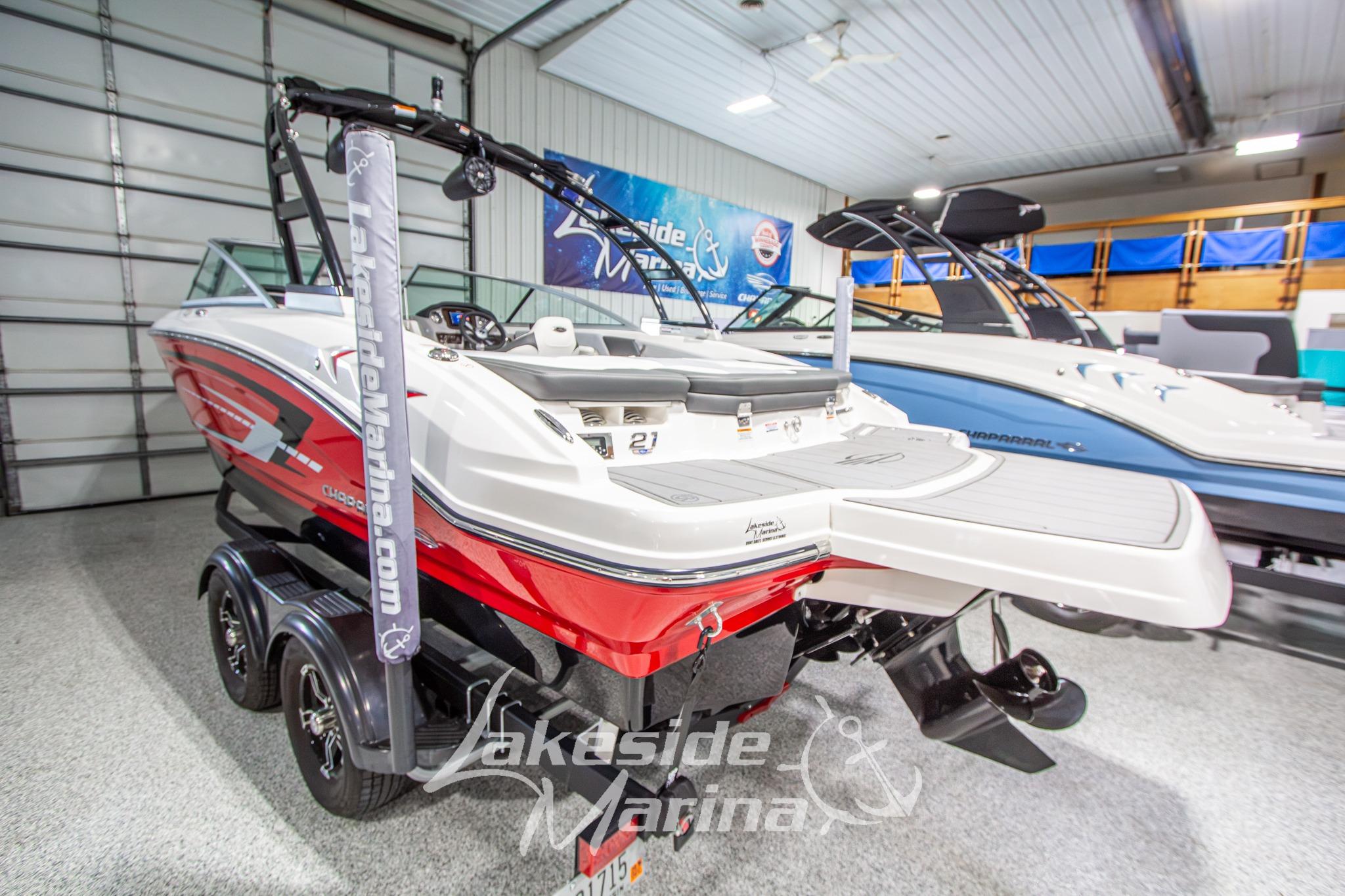 2022 Chaparral 21 SSi boat in showroom, red and white design, on trailer.