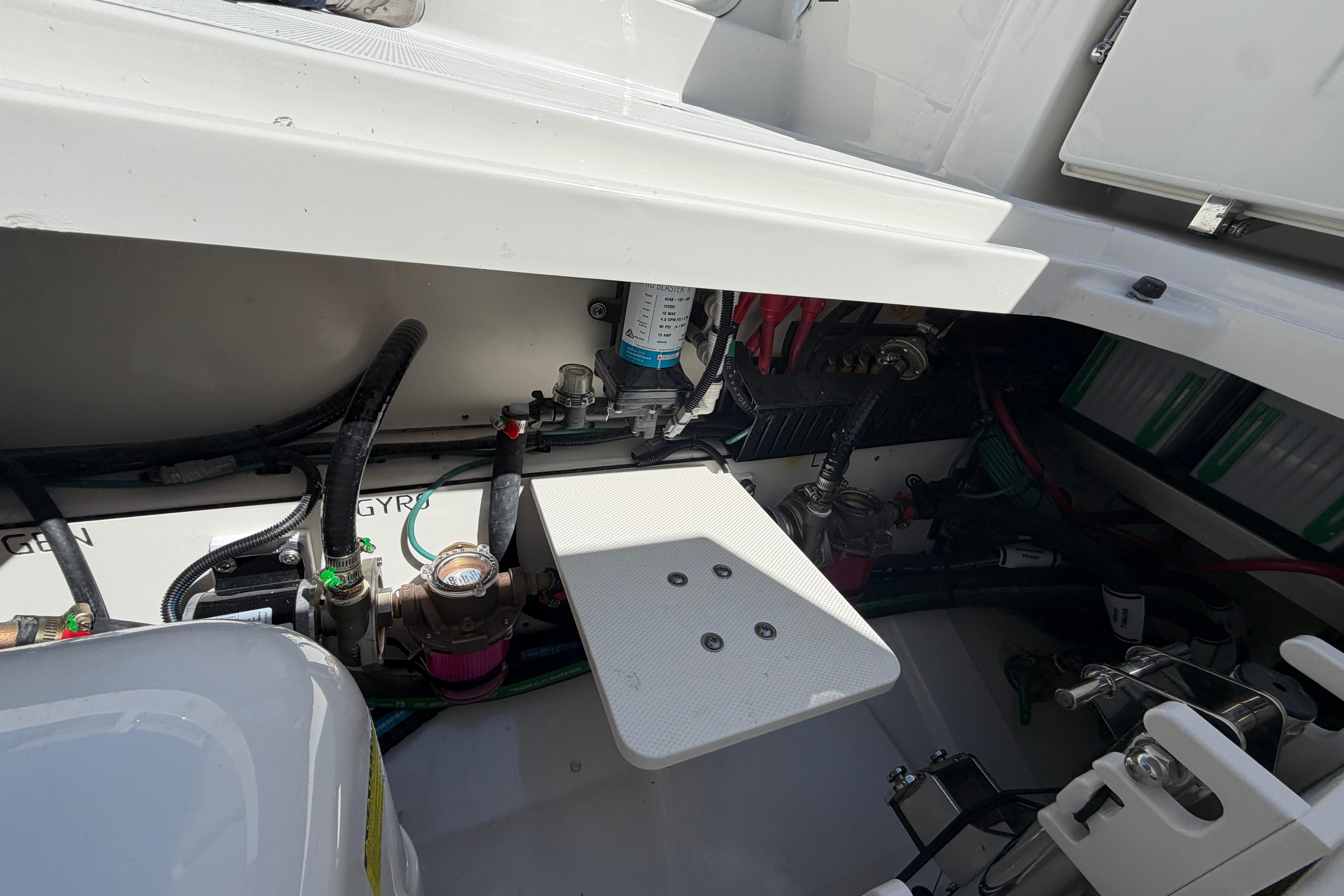 Engine compartment of 2026 Pursuit S 358 Sport boat, showcasing mechanical components and wiring.
