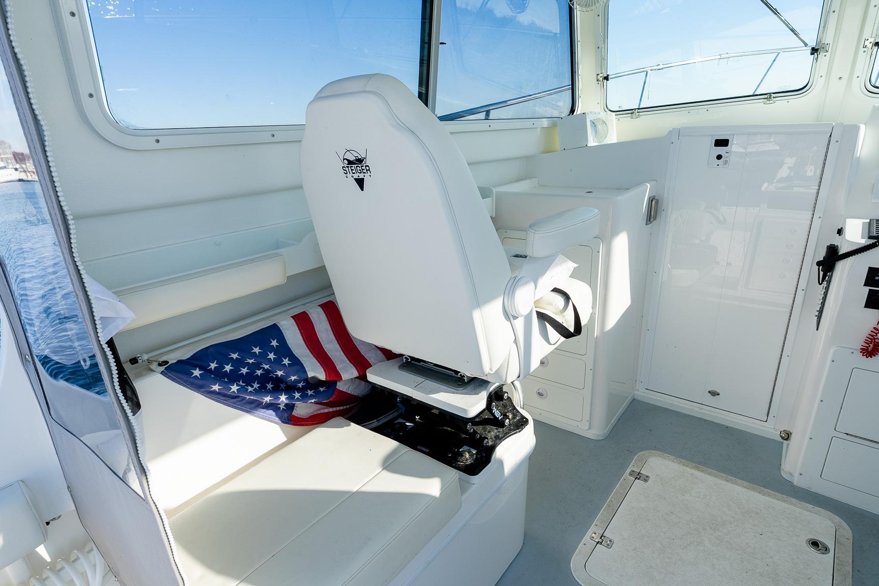 2024 Steiger Craft 31 Fisherman interior with captain's chair and American flag.