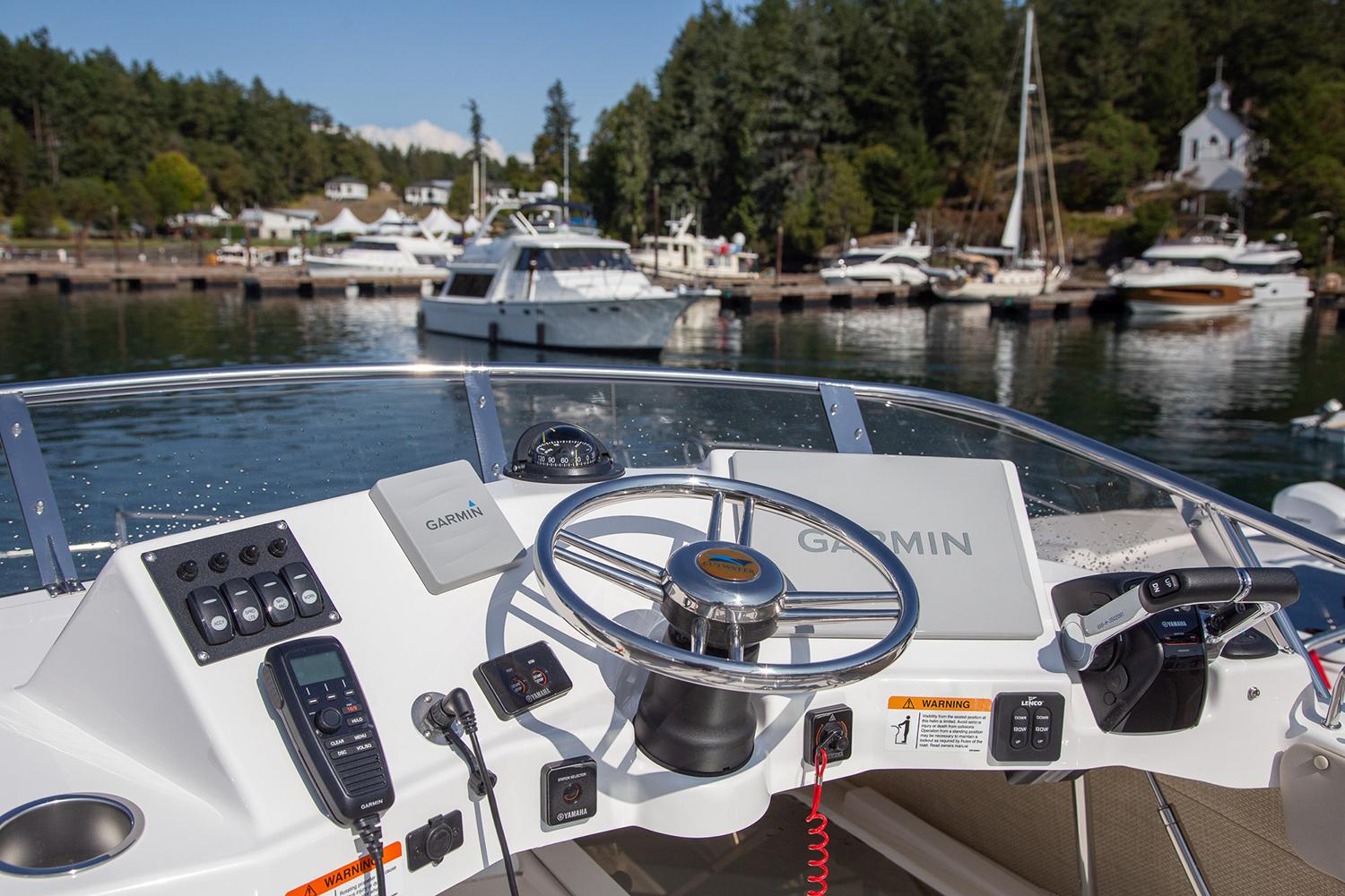 Manufacturer Provided Image: 2025 Cutwater C-32 CB boat helm with Garmin navigation, docked in a scenic marina.