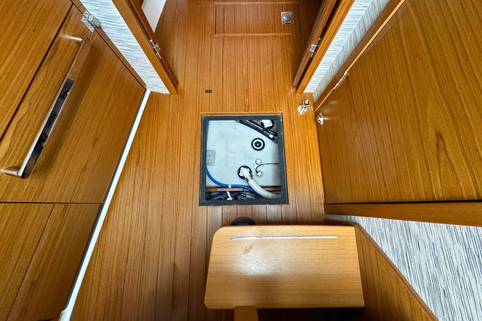 Tiara Yachts 39 LE 2027 interior with open floor hatch, showcasing wooden flooring.