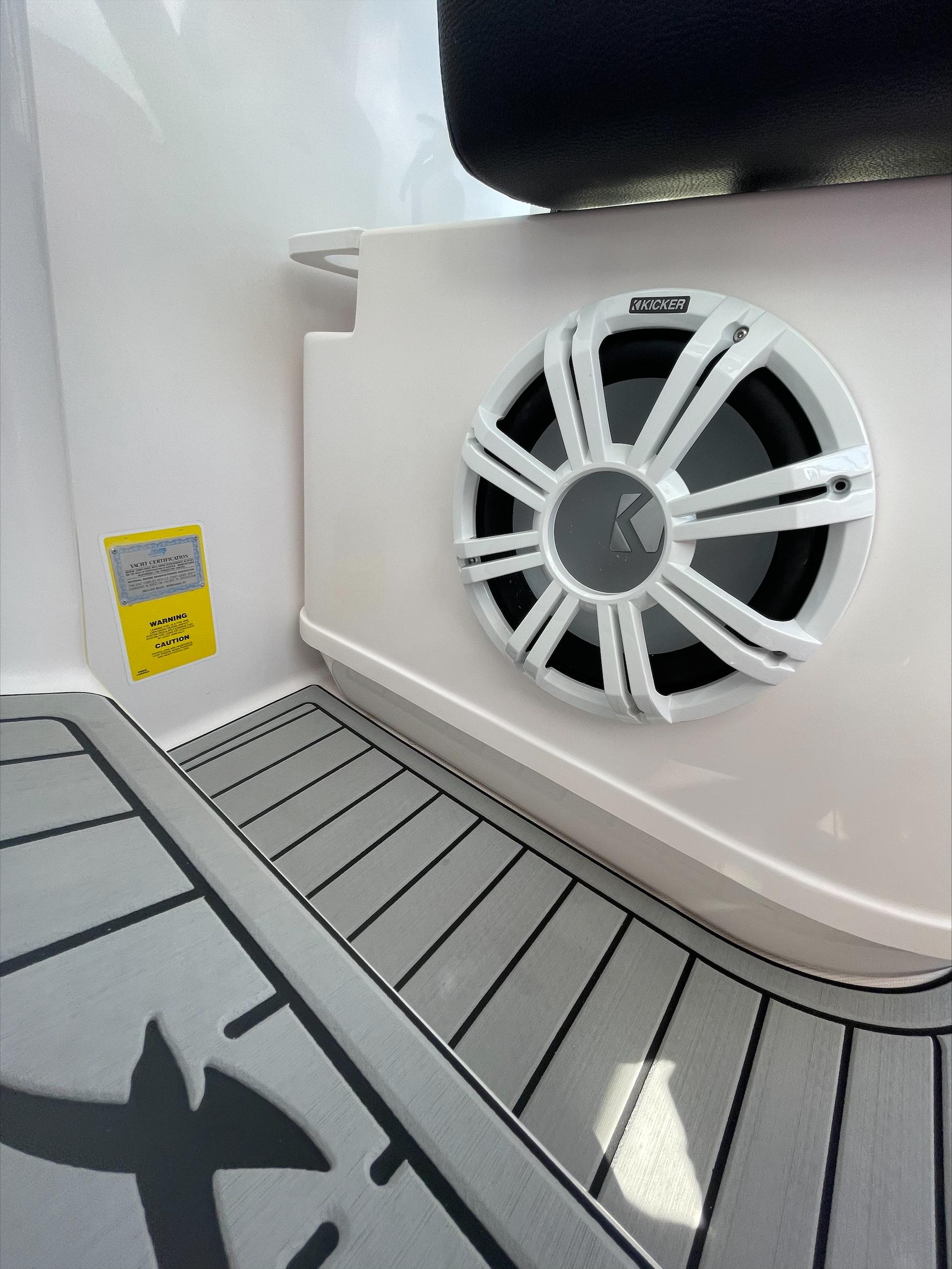 Close-up of a speaker on a boat with gray flooring.