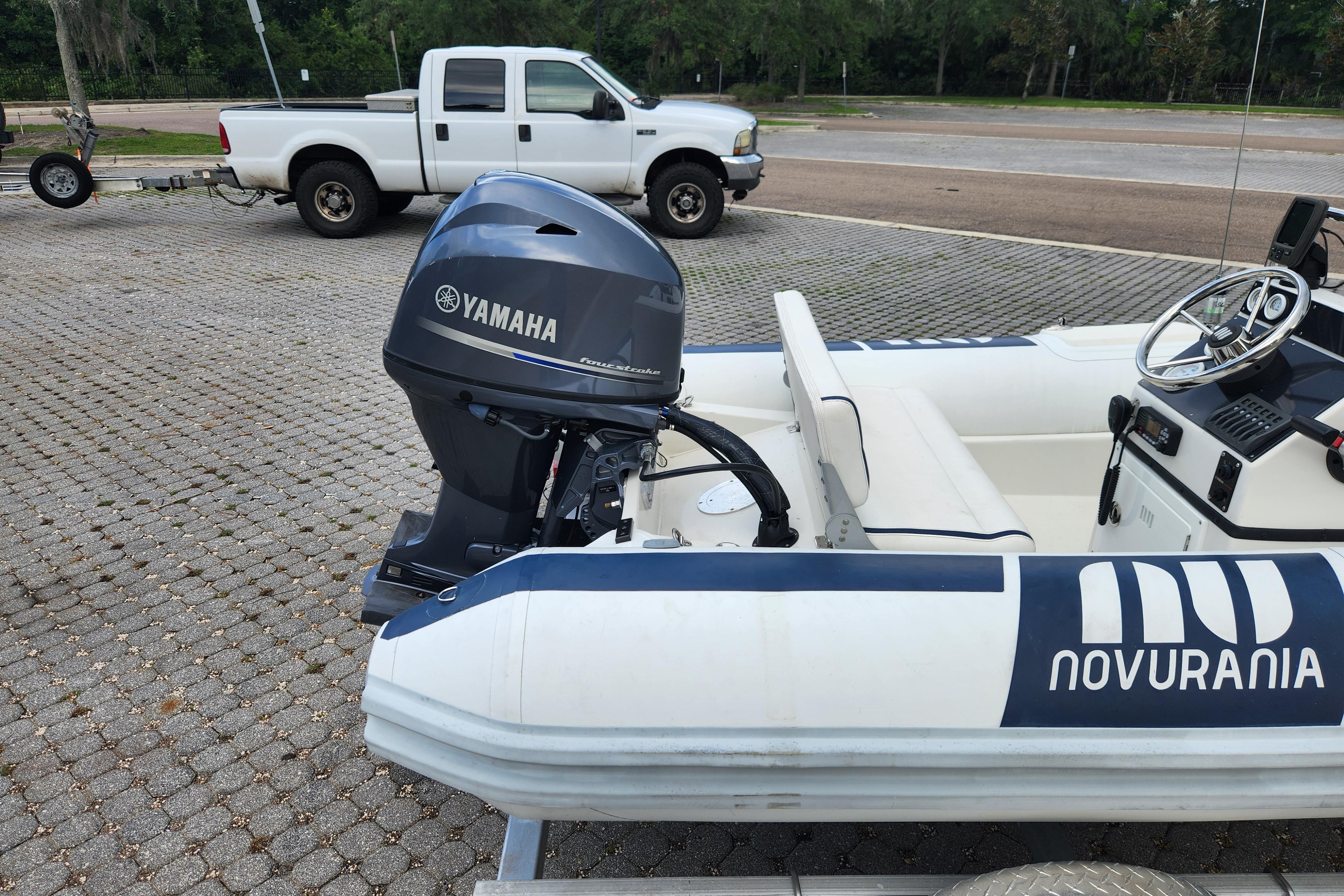 2019 Novurania DL 400 boat with Yamaha outboard motor, parked near a white truck.