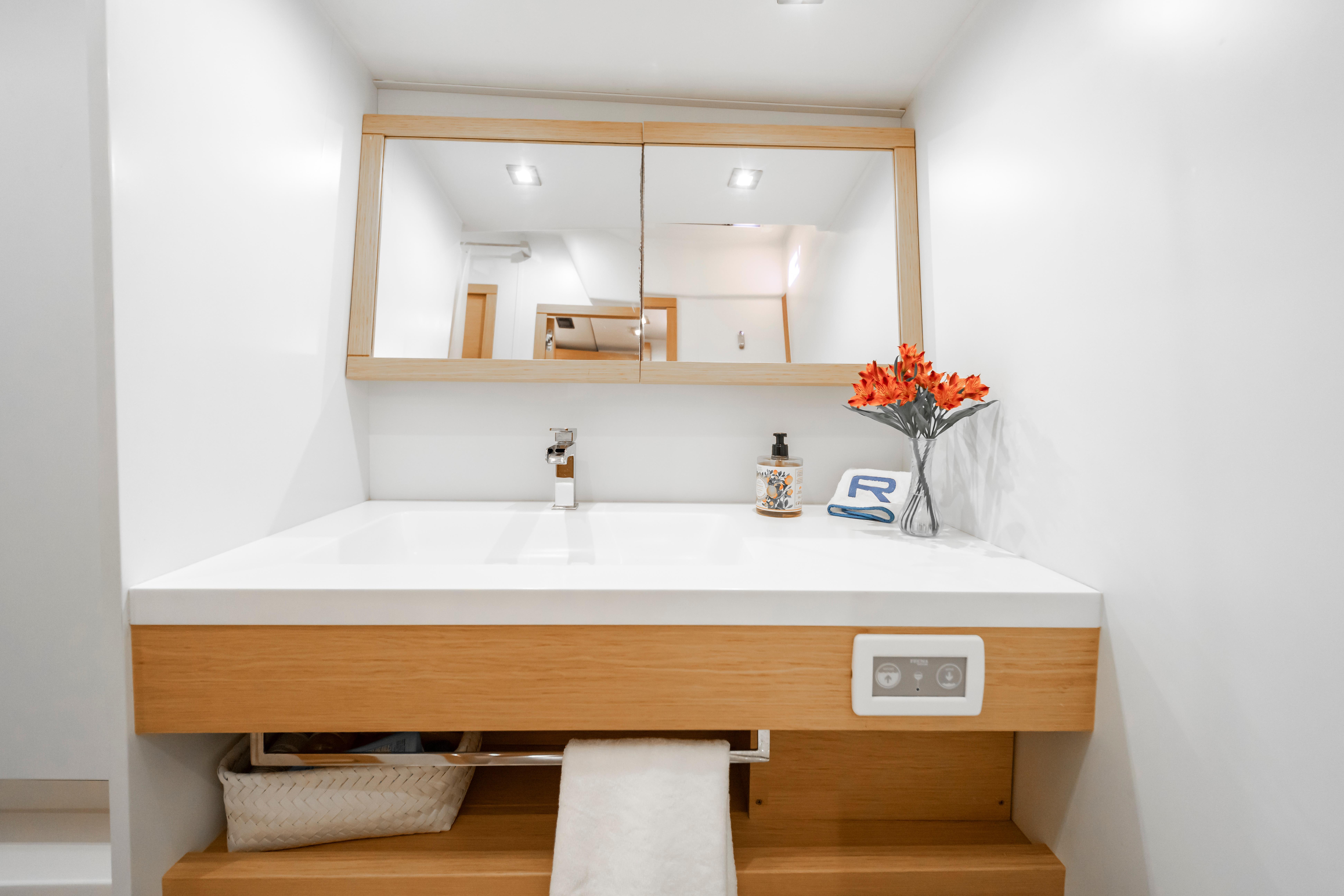 Modern bathroom vanity on 2016 Grand Soleil 58 yacht, featuring mirror and floral decor.
