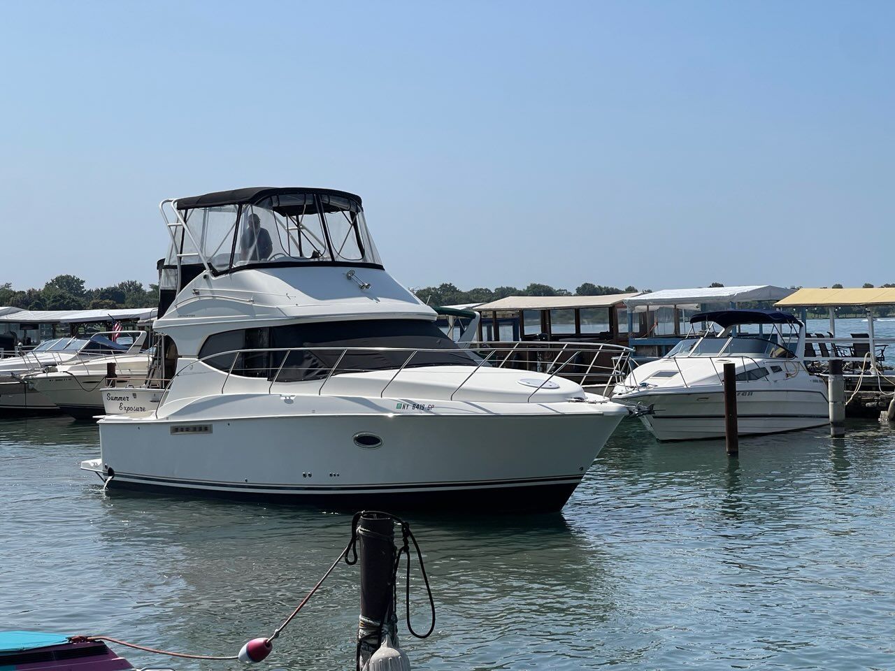 A 2007 Silverton 33 Convertible boat is docked on the water.