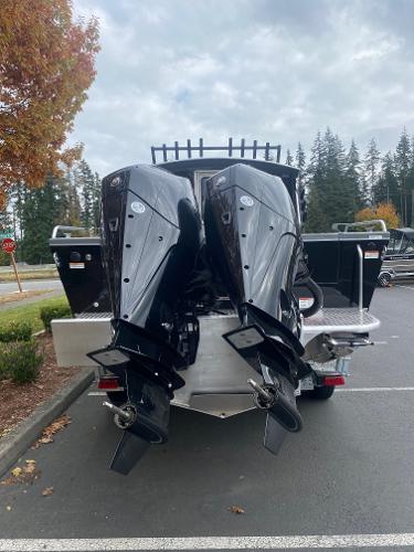 2025 Spartan 26 Maximus boat with dual outboard motors in a parking lot.