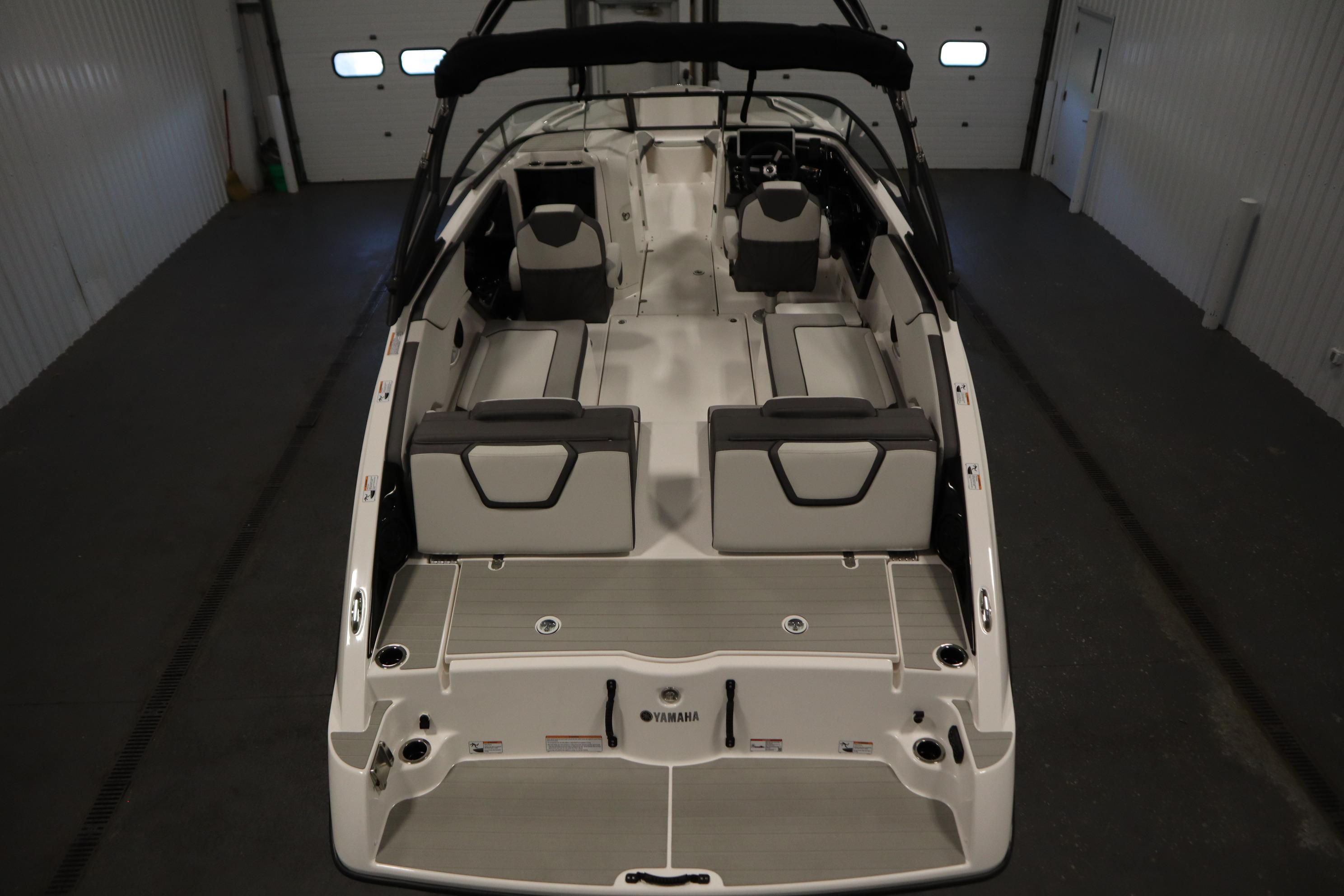 2026 Yamaha Boats AR250 interior view, showcasing spacious seating and modern design in a garage setting.