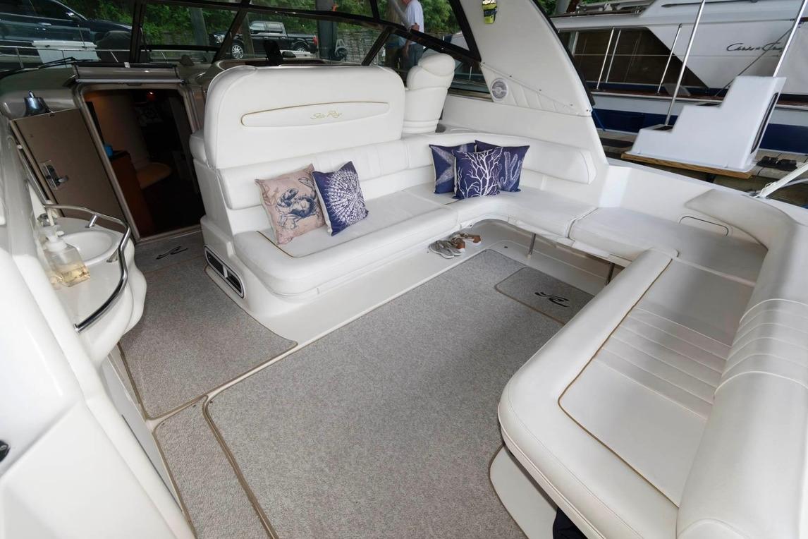 Luxurious interior of a 1999 Sea Ray Sundancer 400 yacht with plush seating and decorative pillows.