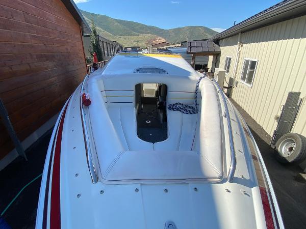 2002 Advantage Victory boat with white seating, docked between buildings, mountain view in background.