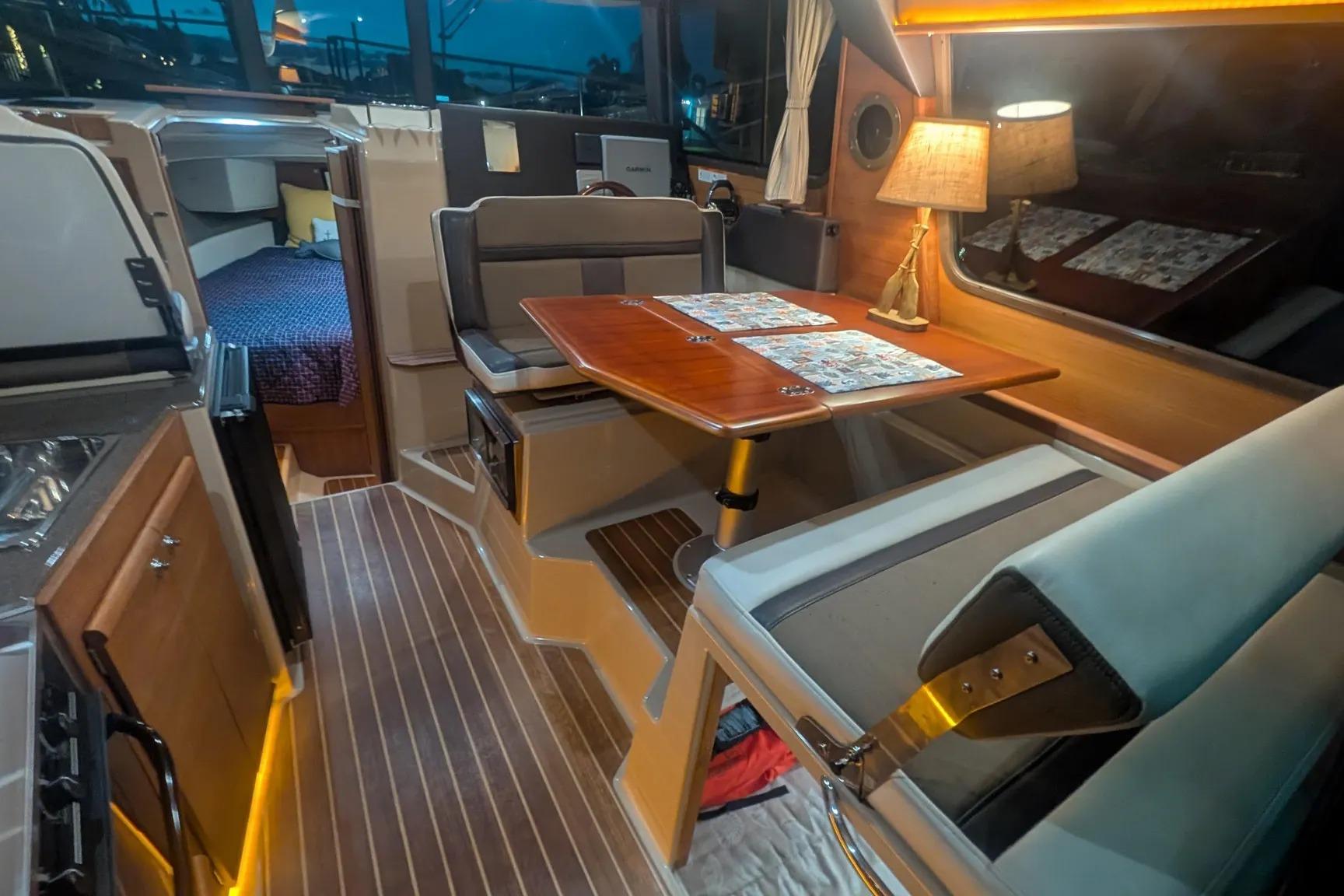 Interior of 2015 Ranger Tugs R-29 S, featuring cozy dining area and elegant wood finishes.