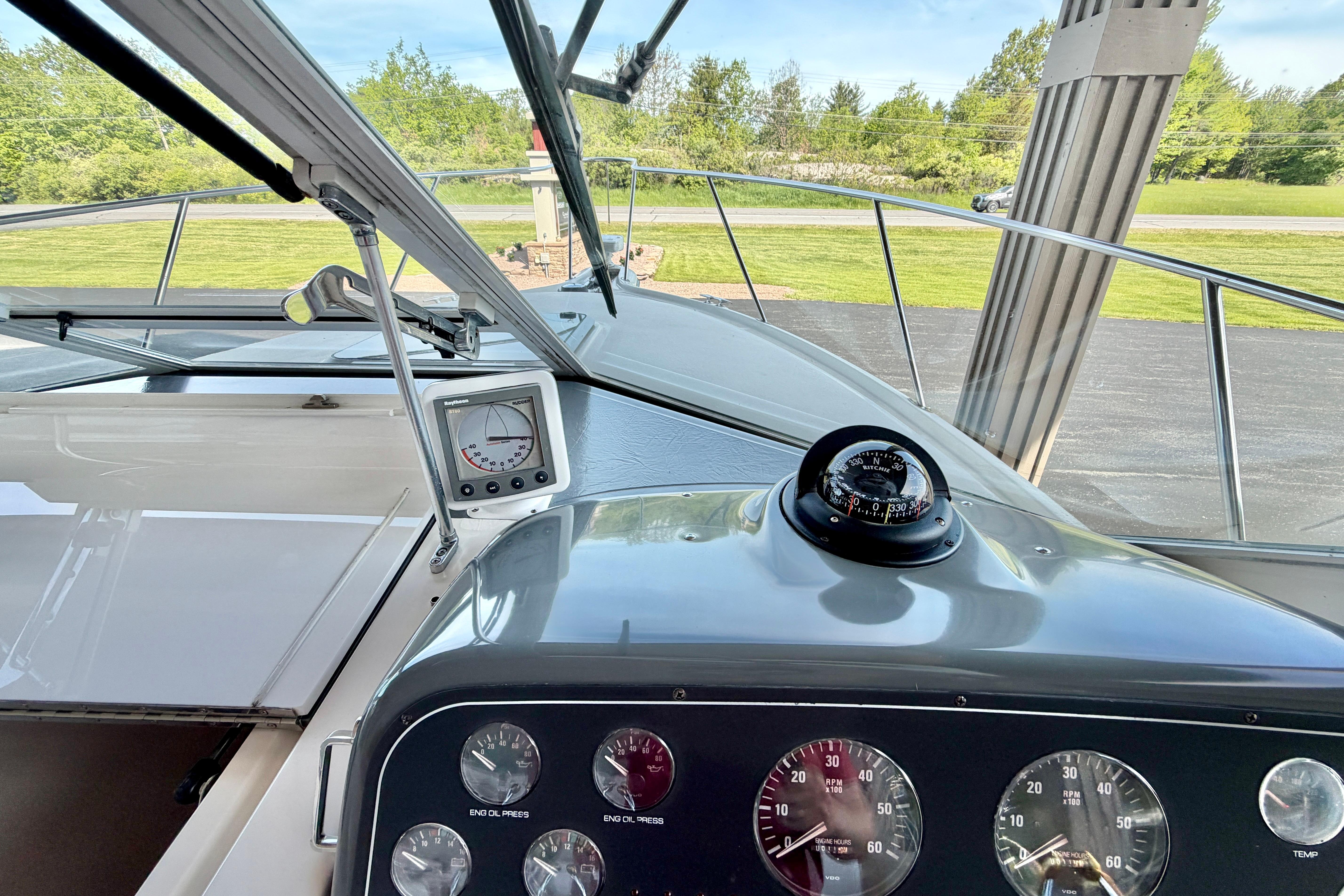 1999 Tiara Yachts 2900 Coronet dashboard with gauges and compass, scenic outdoor view.
