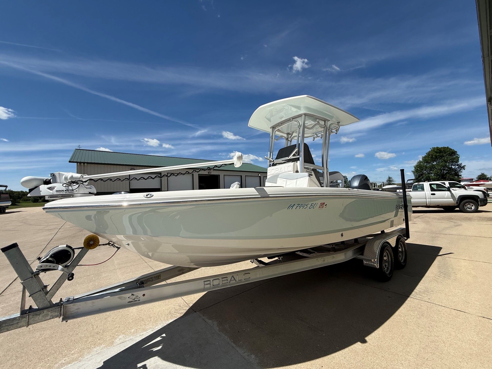 2021 Robalo 226 Cayman boat on trailer under blue sky.