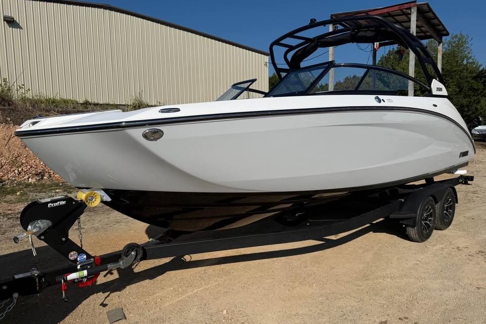 2026 Yamaha Boats 252S on trailer, sleek white design, parked outdoors.