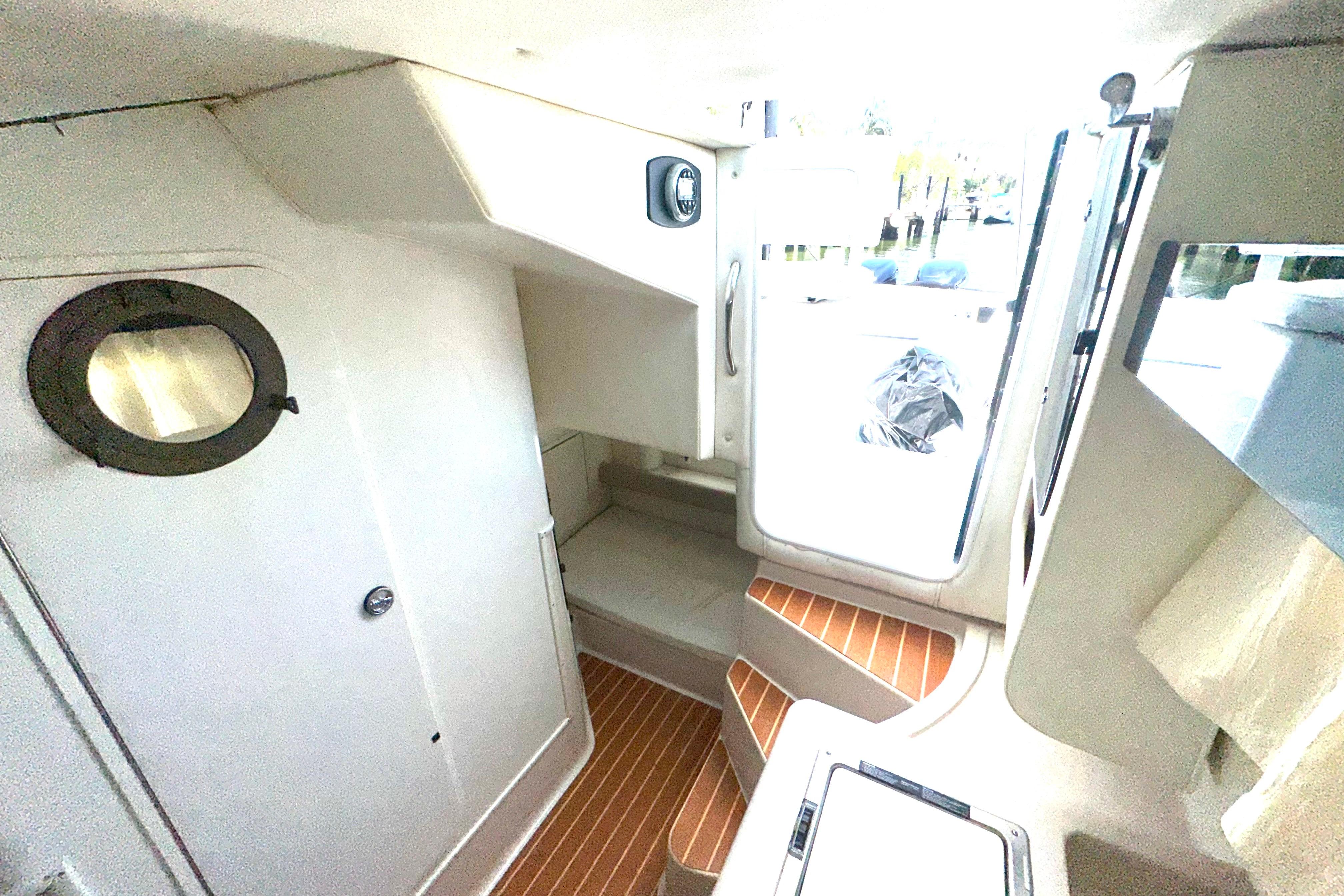 Interior of 1994 Pro-Line 2950 Walkaround boat with wooden steps and porthole window.