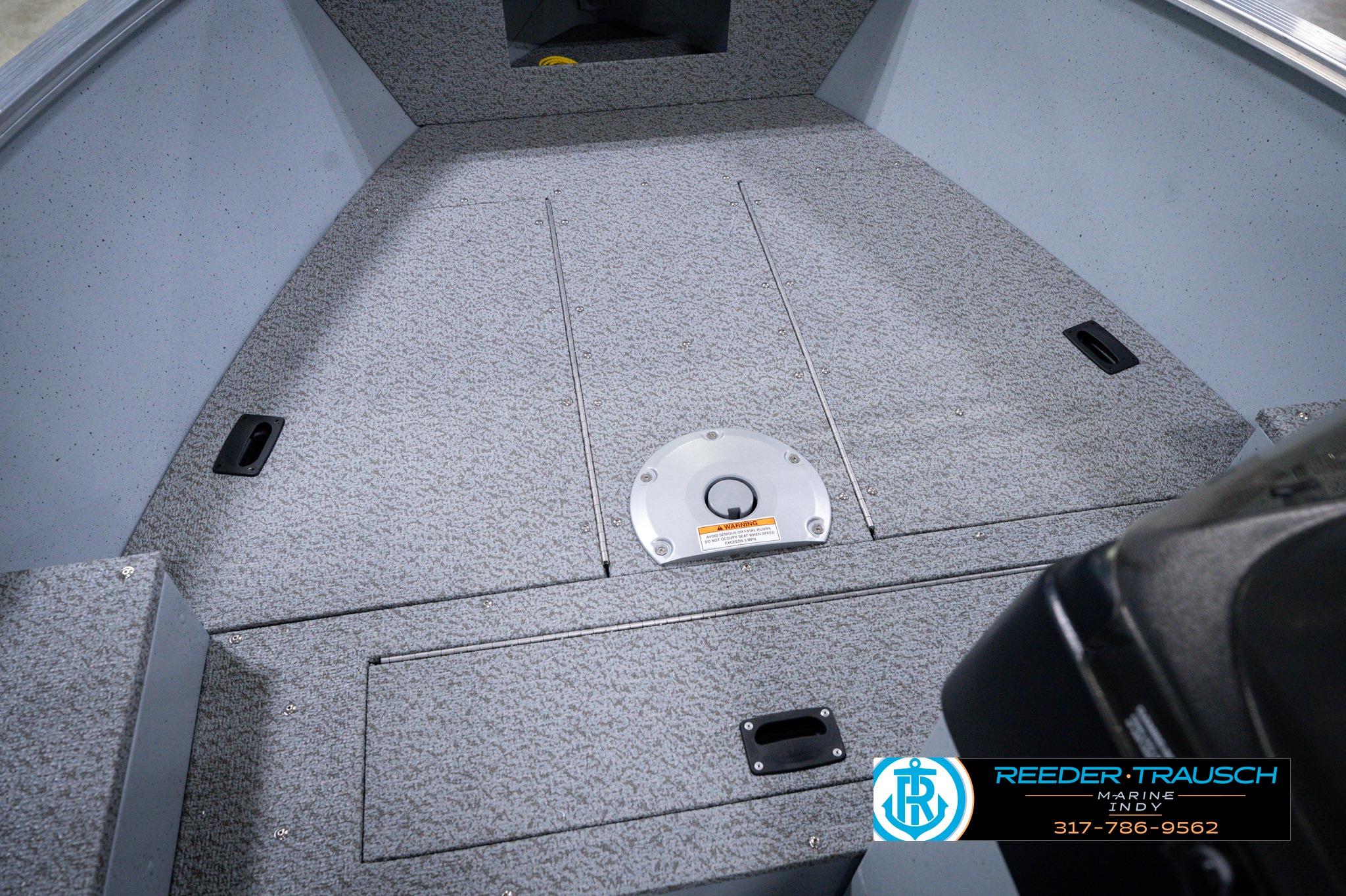 2026 Lund 1600 Fury SS boat interior with carpeted deck and storage compartments.