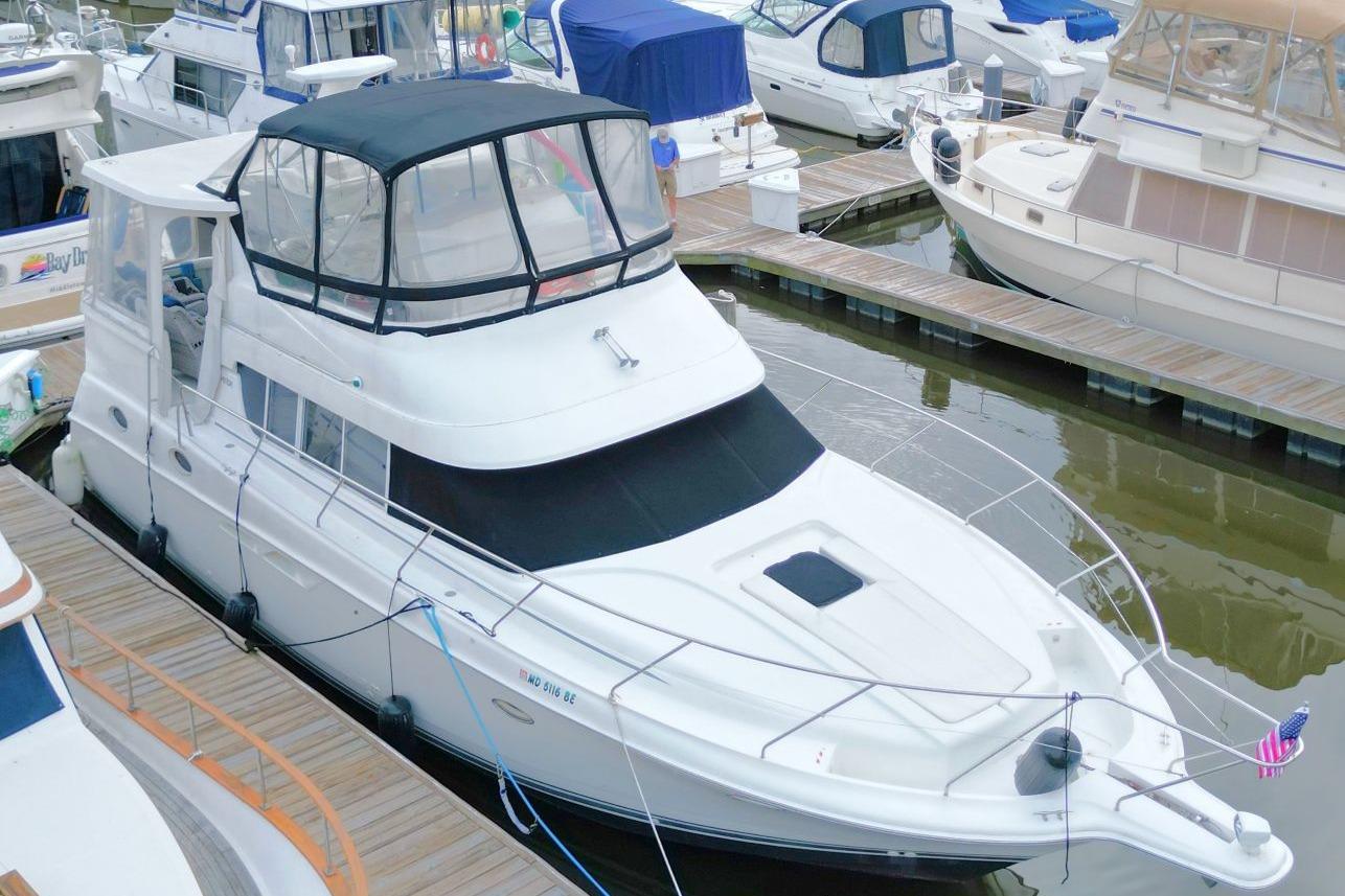 1997 Silverton 402 Motor Yacht docked at marina, featuring sleek design and spacious upper deck.