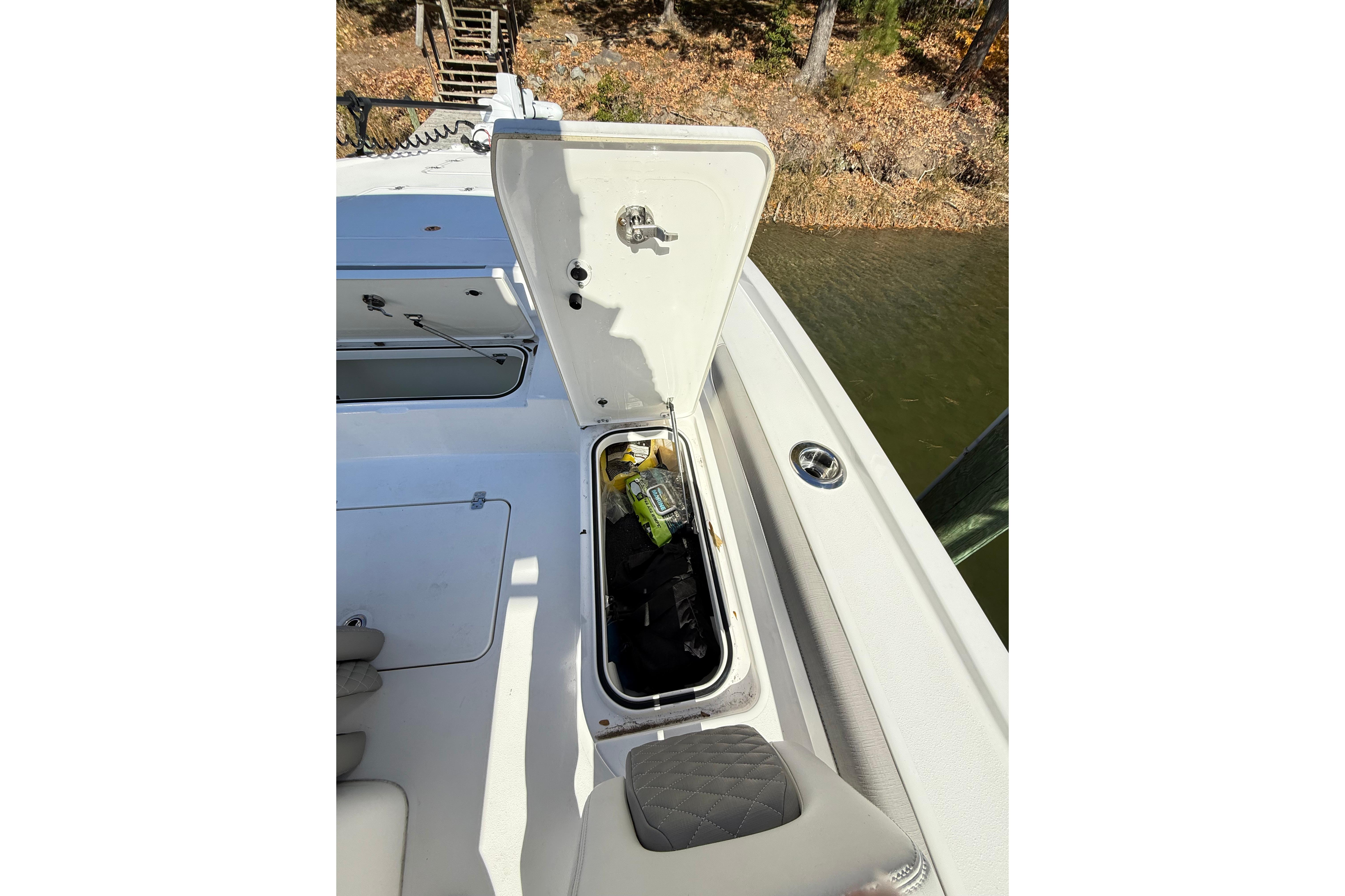 2023 Caymas 281 HB boat storage compartment open by the water.