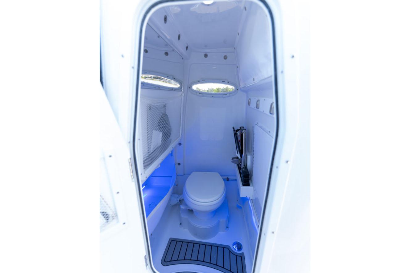 Manufacturer Provided Image: 2026 Sea Hunt Ultra 255 SE boat interior with modern marine toilet and blue lighting.