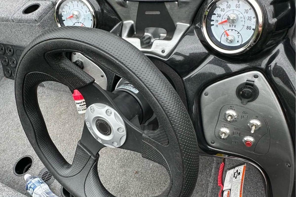 Steering wheel and dashboard of 2022 Bass Tracker 195TXW boat, featuring gauges and controls.