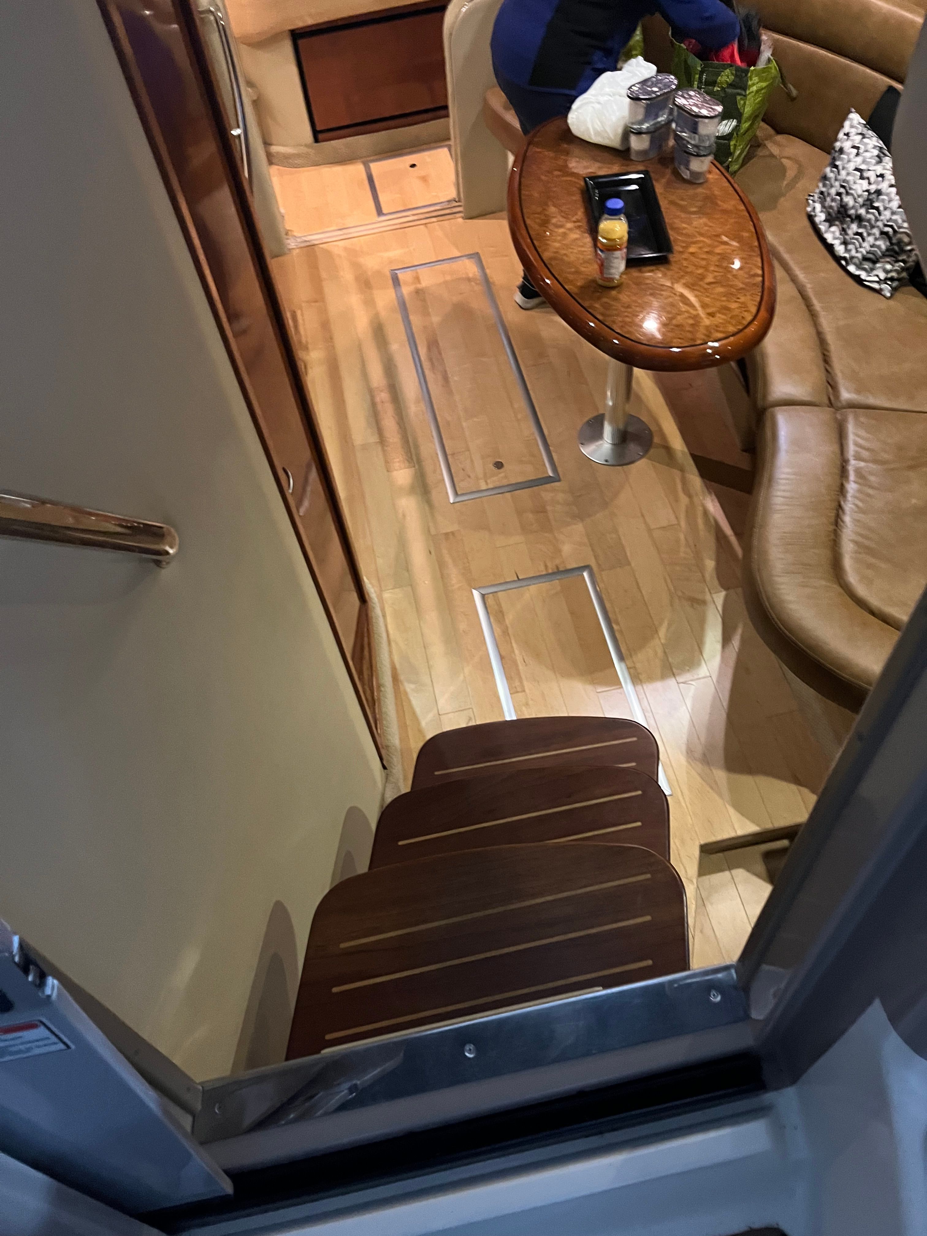 Interior of a 2005 Sea Ray Sundancer yacht with wooden floor and leather sofa.
