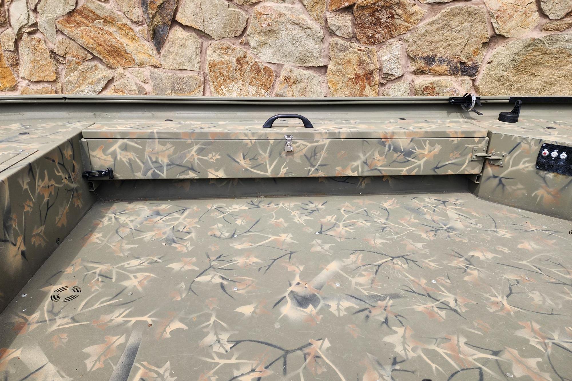 2022 GRIZZLEY 1654SPT boat interior with camouflage pattern and stone wall background.