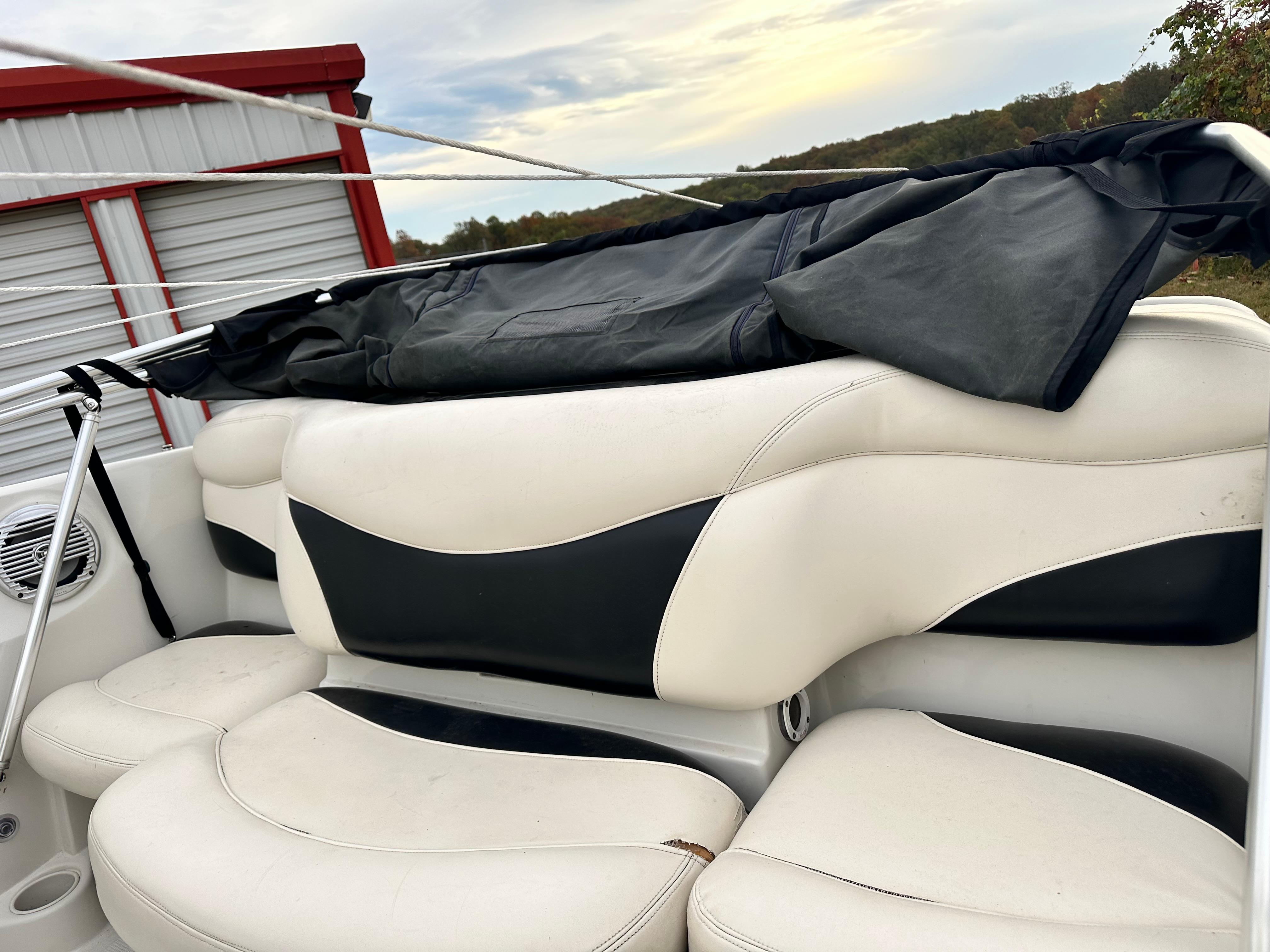 2013 Tahoe Q4i boat interior with white and black seating, stored outdoors.
