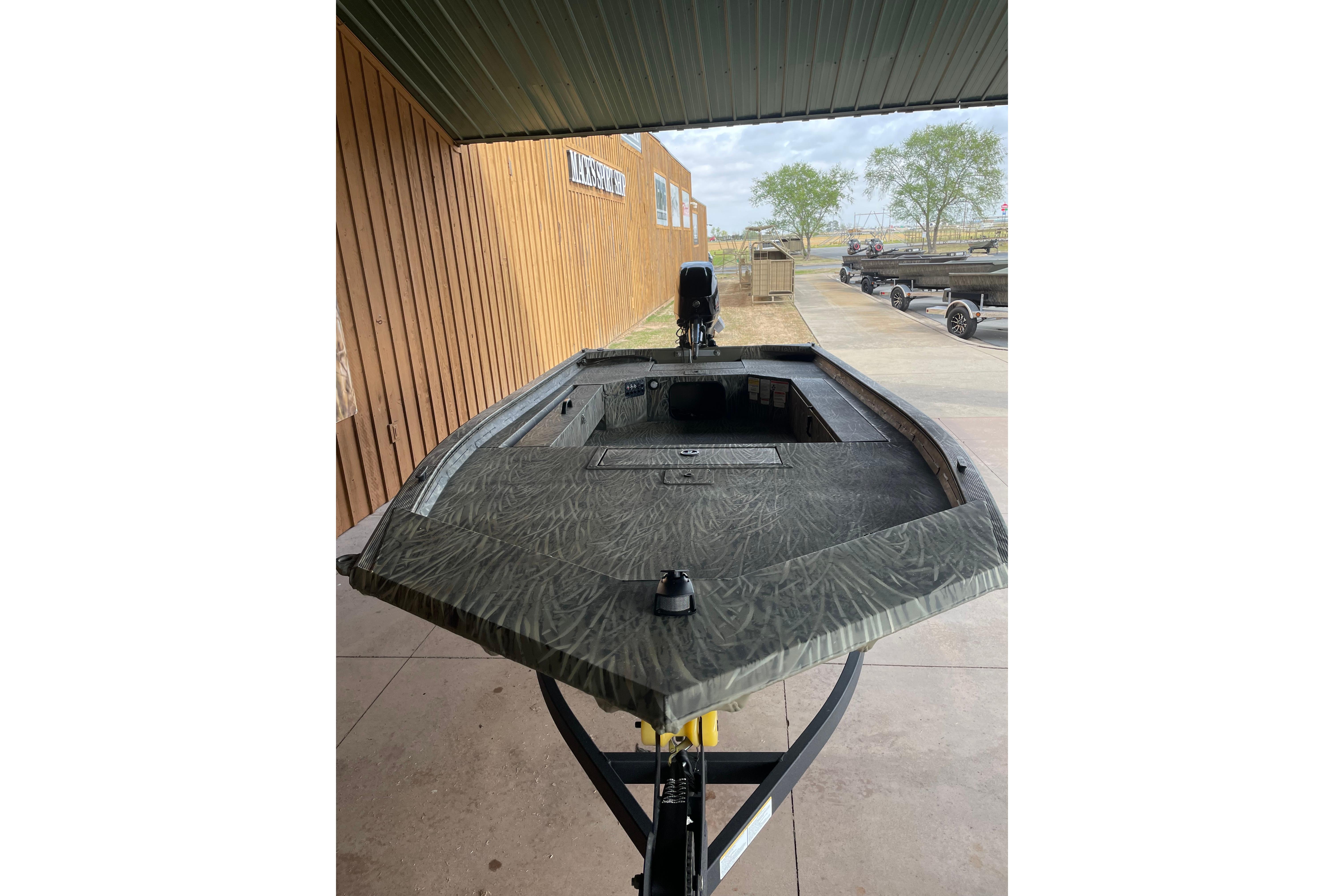 2026 Tracker Grizzly 1654 T Sportsman boat displayed outdoors under a canopy.