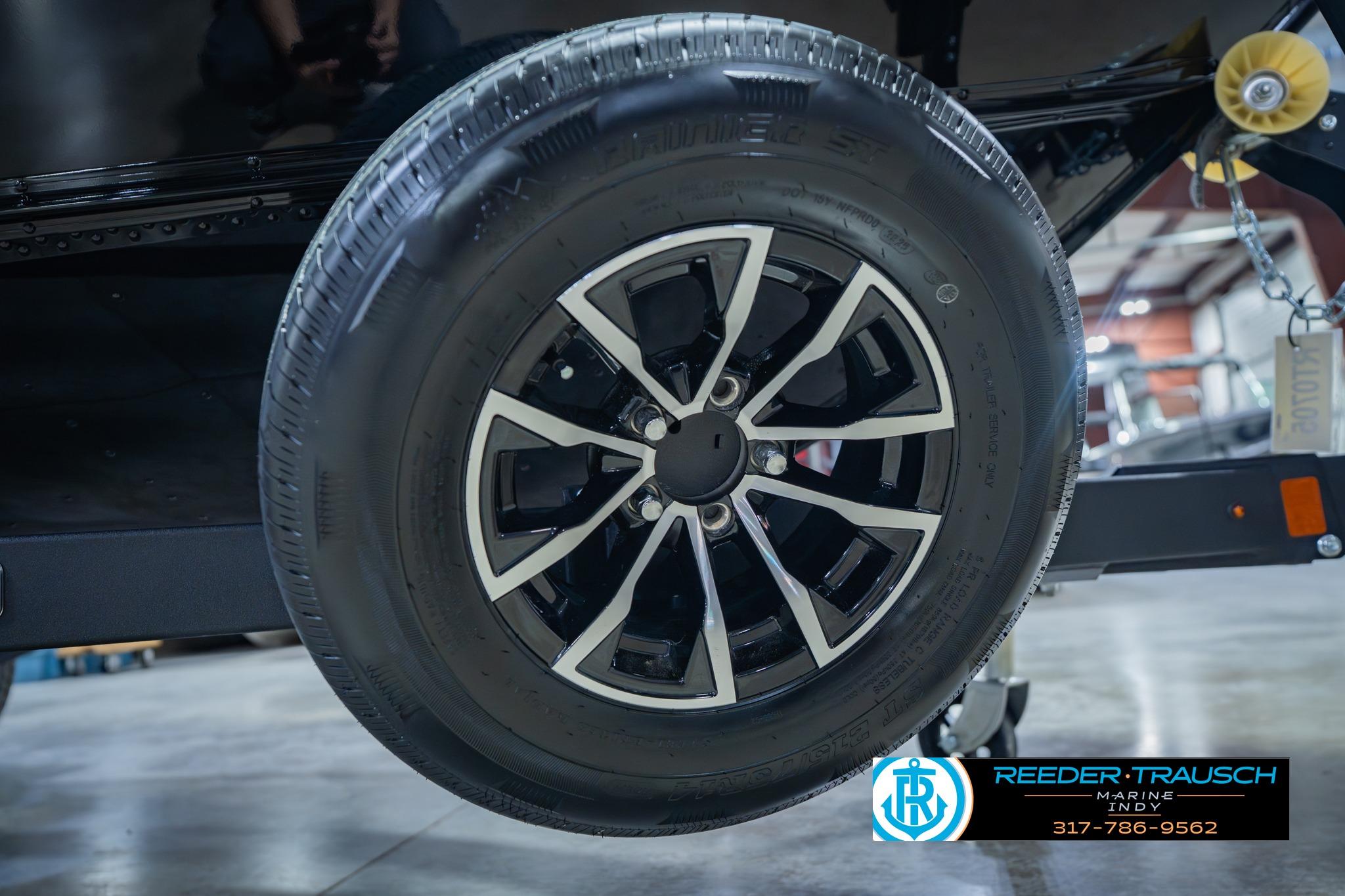 Close-up of a 2026 Lund 1775 Impact XS trailer wheel in a showroom setting.