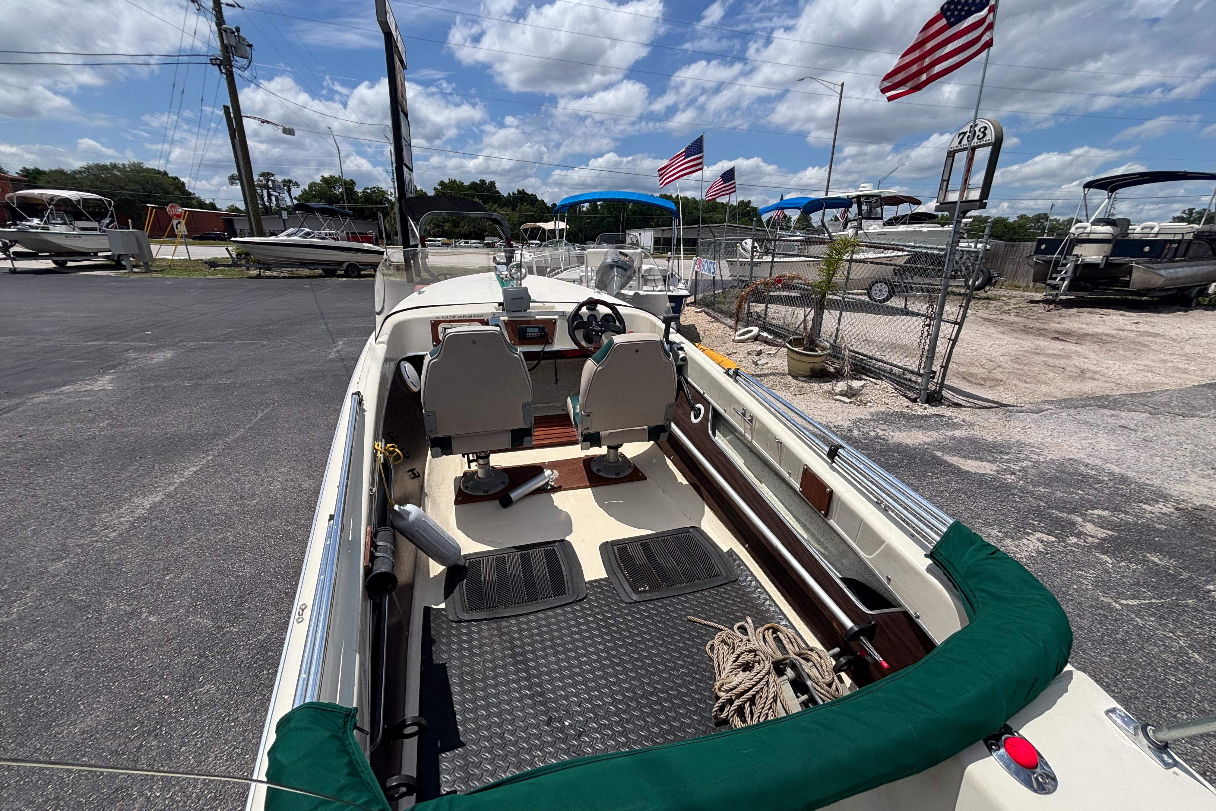 1966 Mohawk 15 boat interior with steering wheel, seats, and American flags in the background.